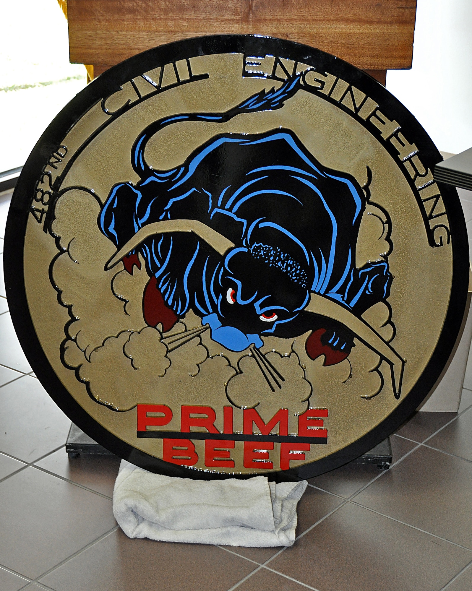 482nd Prime Base Engineering and Emergency Force display the squadron emblem to be placed in their new pavilion, Mar. 22. The Emblem will be cemented to the floor in the center of the pavilion once construction is complete. (U. S. Air Force Photo/Senior Airman Jacob Jimenez, 482nd Fighter Wing Public Affairs).