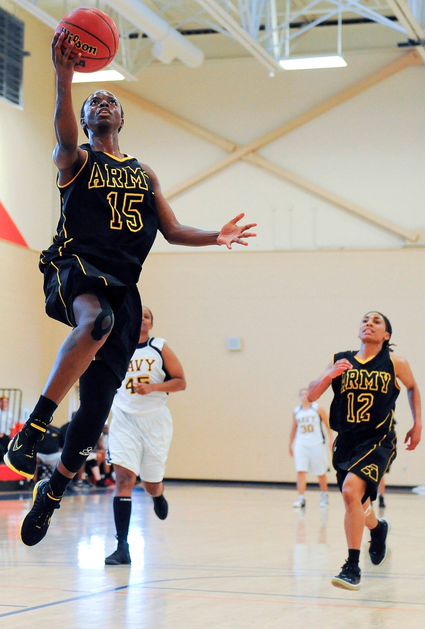 Specialist Kimberly Smith attempts a layup, while Spc. Ashley Bowman races
to guard her during the Army versus Navy basketball game. At half time the
Navy was up with 34 points with the Army trailing behind at 27 points. The
Navy won the game with 62 points, while the Army finished with 58. (U.S Air
Force photo by Chris Cokeing)
