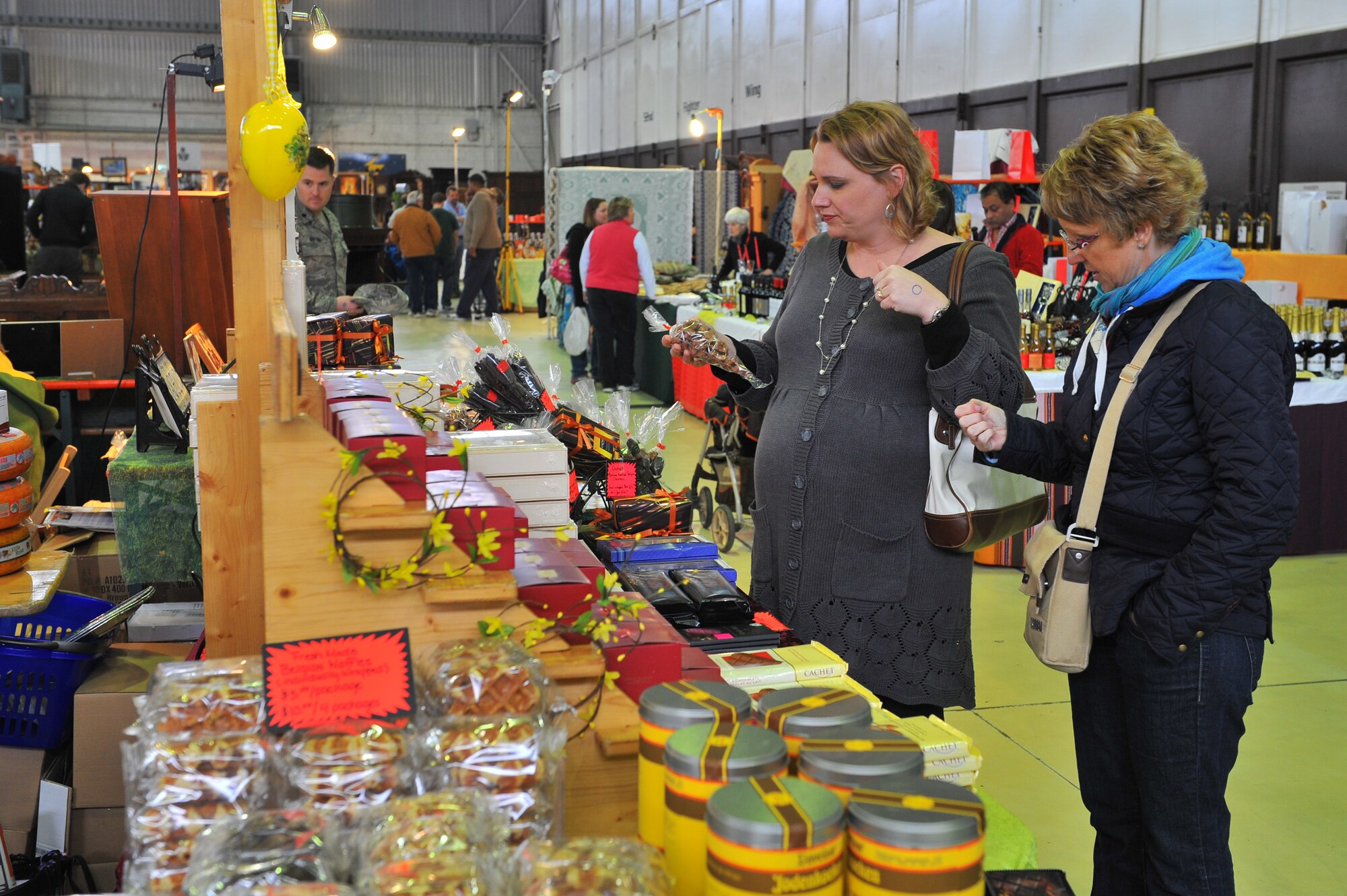 SPANGDAHLEM AIR BASE, Germany – Chi Anne McGrew, left, wife of Thomas McGrew, 52nd Civil Engineering Squadron, and Philippa Brathoude shop for assorted chocolate treats at the spring bazaar here March 30. The Spangdahlem Spouses and Enlisted Members Club hosts the bazaar annually allowing vendors from across Europe to share their products with military members and their families. Products include foodstuffs, furniture and traditional German décor. (U.S. Air Force photo/Airman 1st Class Dillon Davis)