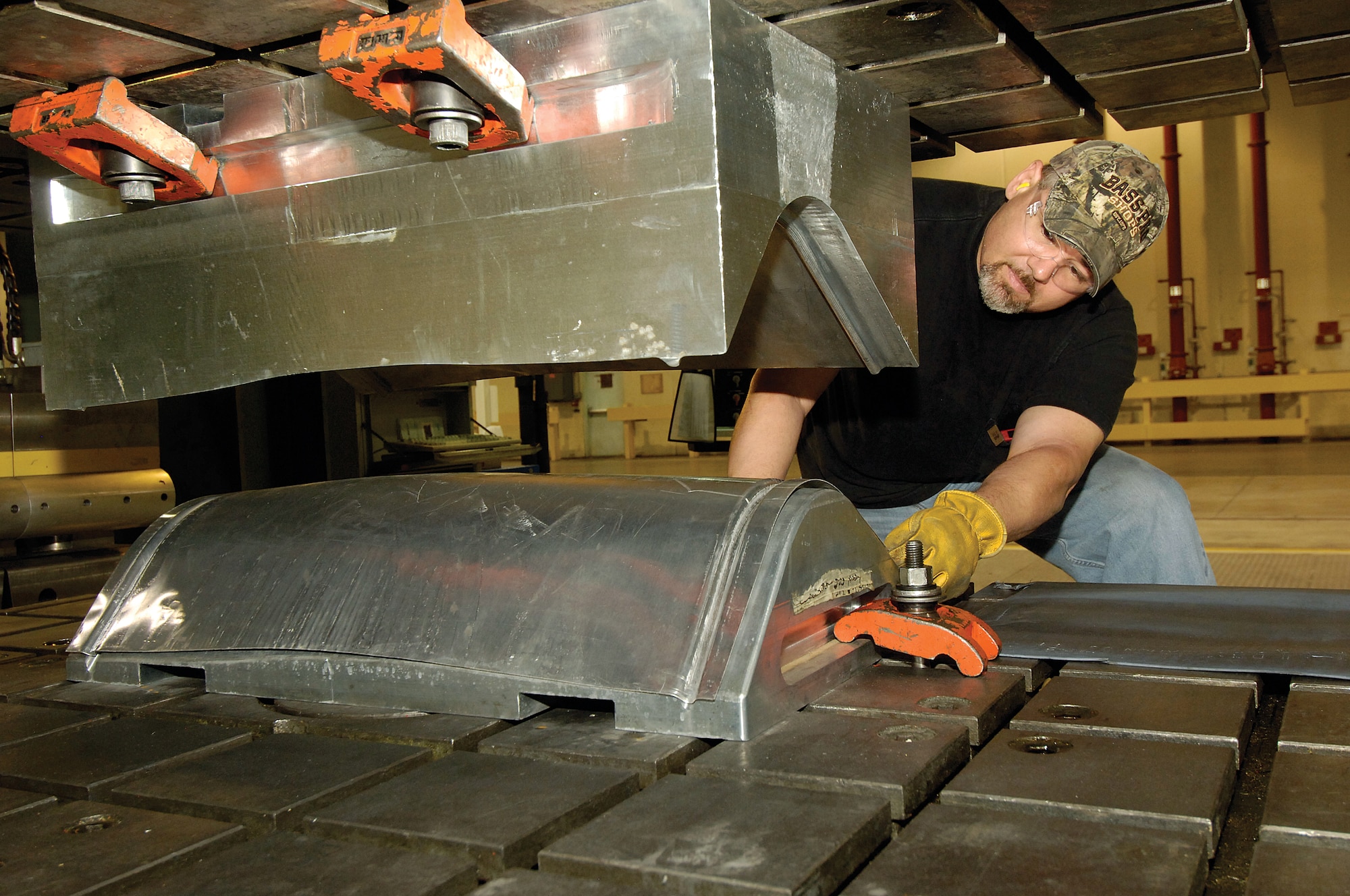 Ron Simon looks at a KC-135 refueling boom side skin pressed into shape on a 300-ton stretch draw press in the Sheet Metal Manufacturing Shop located in Bldg. 9001.  The shop of approximately 35 mechanics and its large machines moved from Bldg. 3001 last year. (Air Force photos by Margo Wright)