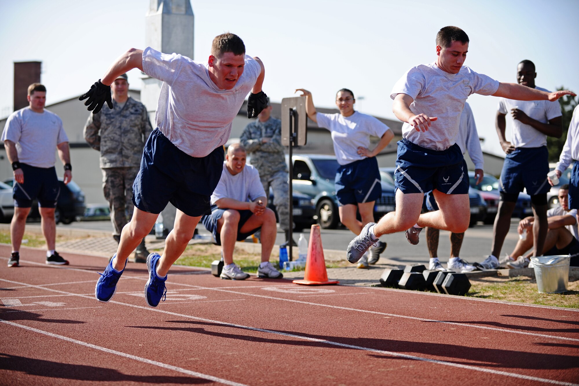 SPANGDAHLEM AIR BASE, Germany – Staff Sgt. Timmy Edge, left, 52nd Equipment Maintenance Squadron, and Tech. Sgt. Jason Quadros, 52nd Component Maintenance Squadron, long jump during a relay for the Iron Flight Competition at the track here March 28. The quarterly competition is an incentive program intended to build comraderie and test the mental and physical endurance of the participating squadron members. Four teams participated in the six-person team competition that consisted of three different events. The 52nd Equipment Maintenance Squadron ammo team won the competition after a three-way tie-breaker rope-climbing event against the 52nd Civil Engineer Squadron and CMS. (U.S. Air Force photo by Airman 1st Class Matthew B. Fredericks/Released)