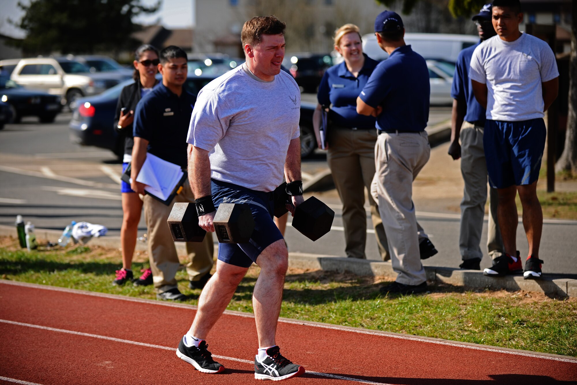 SPANGDAHLEM AIR BASE, Germany – Master Sgt. Carlos Crasta, 52nd Component Maintenance Squadron, runs while holding two 85 pound dumbbells during the Iron Flight Competition at the track here March 28. The quarterly competition is an incentive program intended to build comraderie and test the mental and physical endurance of the participating squadron members. Four teams participated in the six-person team competition that consisted of three different events. The 52nd Equipment Maintenance Squadron ammo team won the competition after a three-way tie-breaker rope-climbing event against the 52nd Civil Engineer Squadron and CMS. (U.S. Air Force photo by Airman 1st Class Matthew B. Fredericks/Released)