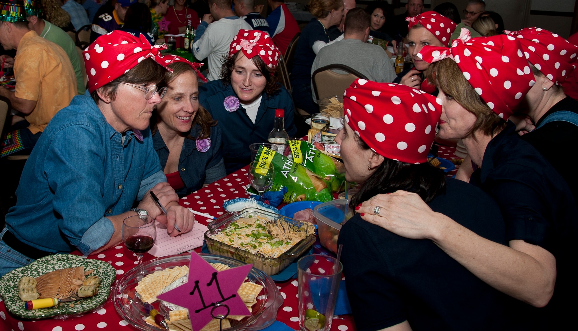 A table of service members and military spouses huddle together, dressed as Rosie the Riveter, to discuss one of the trivia questions during the Joint Base McGuire-Dix-Lakehurst Trivia Night March 23 at Tommy B’s Community Activities Center. Groups dressed in various costumes ranging all the way from gangsters to surgeons. (U.S. Air Force photo by Airman 1st Class Dennis Sloan/Released)
