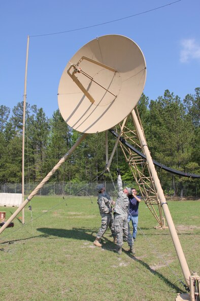 Reynolds Wolf, CNN meteorologist and correspondent, and Tech. Sgt Jeffrey Ogershock, 53rd Combat Communications Squadron radio frequency transmissions crew chief aligns Tropospheric Scatter terminal (TRC 170) as Ferre Dollar documents the training here March 28.  A three-person CNN team visited the 689th Combat Communications Wing to experience what it is like to be a combat communications Airman for the day. Combat Comm provided hands-on experiences that showcased the physical, technical, and mental readiness of Combat Communicators.  (U.S. Air Force photo by Robert Talenti)