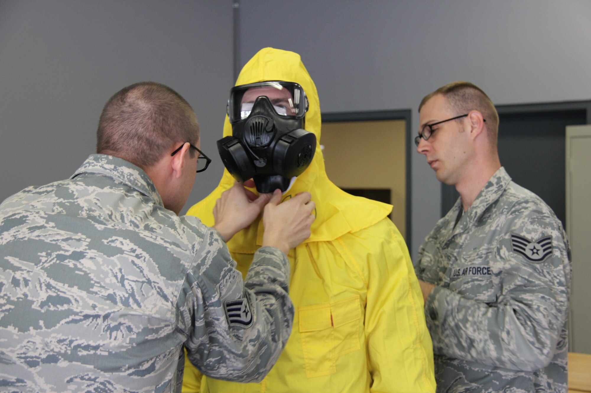 – Staff Sgt. Timothy Wheeler and Staff Sgt. Joshua Ray, both Hammer ACE, (Adaptive Communication Element) operators, dress out Reynolds Wolf, CNN meteorologist and correspondent, in a ‘banana suit’ or radioactive coverall March 28. A three-person CNN team visited the 689th Combat Communications Wing to experience what it is like to be a combat communications Airman for the day. Combat Comm provided hands-on experiences that showcased the physical, technical, and mental readiness of Combat Communicators.  (U.S. Air Force photo by Robert Talenti)