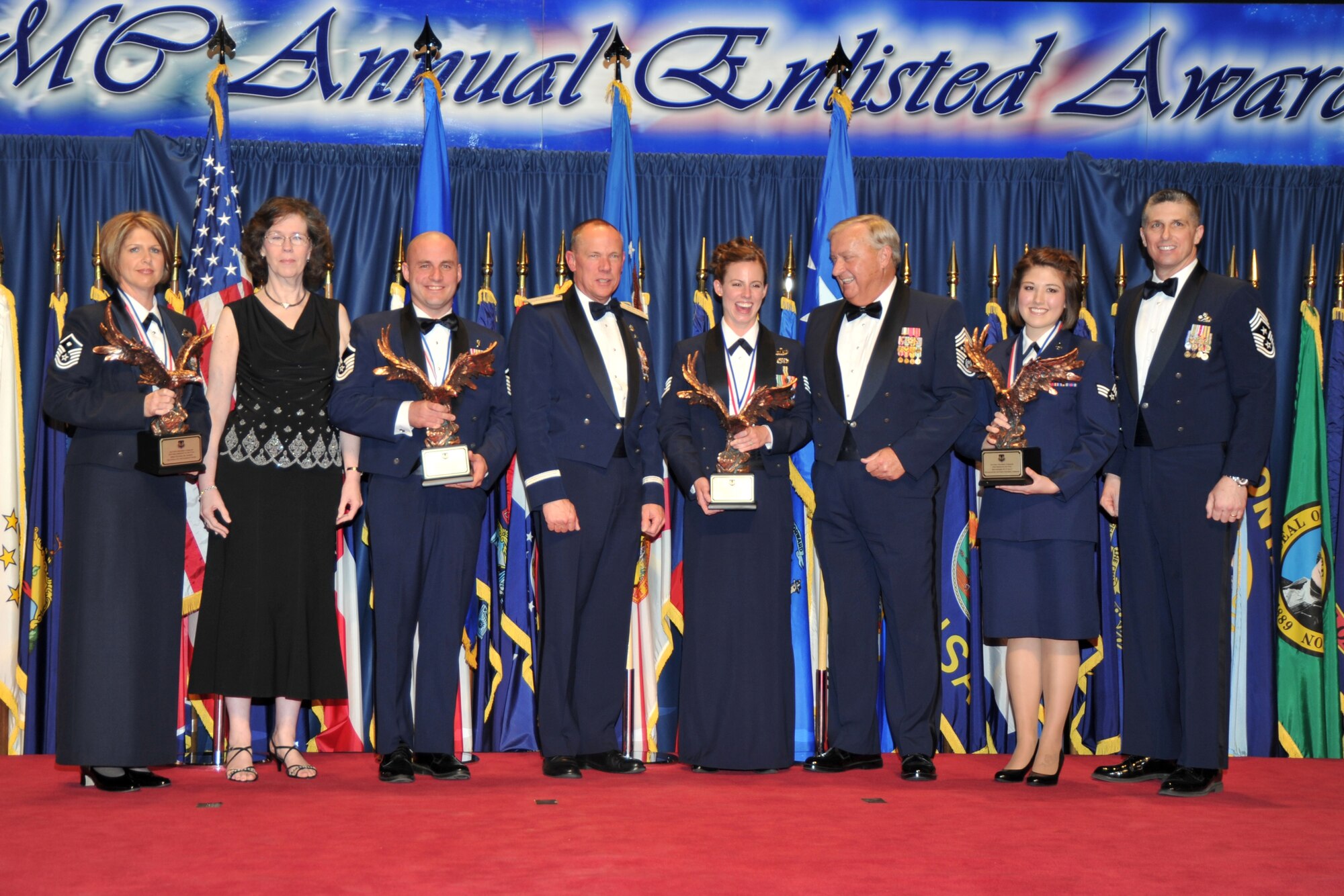 Air Force Materiel Command's Annual Enlisted Award winners for 2011 stand on stage at the ceremony. From left: Master Sgt. Kavina M. Agnew, Tinker Air Force Base, Okla.; Shiela Wallace, Air Force Association Wright Memorial Chapter 212 president; Master Sgt. Alan M. Braden, Wright-Patterson Air Force Base, Ohio; Gen. Donald Hoffman, AFMC commander; Staff Sgt. Linn A. Knight, Eglin Air Force Base, Fla.; retired Chief Master Sgt. of the Air Force James C. Binnicker; Airman First Class Andrea R.P. Ally, Wright-Patterson Air Force Base, Ohio; and Chief Master Sgt. Eric R. Jaren, AFMC command chief. (U.S. Air Force photo/Ben Strasser)