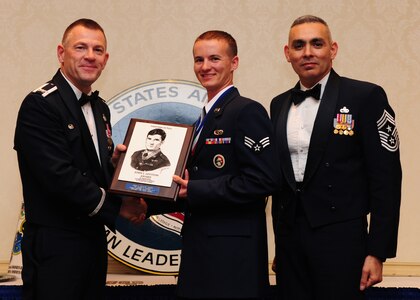 Col. Richard McComb amd Chief Master Sgt. Jose LugoSantiago present the John L. Levitow Award to Senior Airman Ronald Sangston during the Airman Leadership School Class graduation at Joint Base Charleston - Air Base March 22. The award is presented to the student who displays exemplary excellence as both a leader and a scholar. McComb is the JB Charleston commander and LugoSantiago was the 628th Air Base Wing command chief. Sangston is a 437th Aircraft Maintenance Squadron hydraulics systems journeyman, 437th Airlift Wing. (U.S. Air Force photo/Airman 1st Class Chacarra Walker)