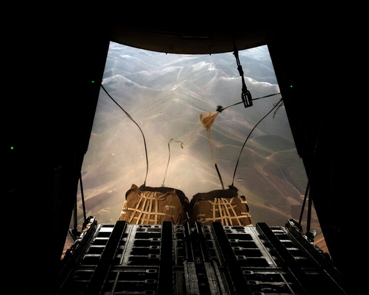 BALA MURGHAB, Afghanistan -- Parachutes attached to cargo pallets begin to open and slow the pallets' descent as they fall toward a forward operating base in Badghis Province, Afghanistan, Feb. 26, 2011. 100th Air Refueling Wing refueling missions enable cargo aircraft to fly from America to remote locations without landing. The 100th ARW public website, www.mildenhall.af.mil is the base’s one official public information site. Airmen and family members can visit the website for timely, accurate information, news, road conditions, bulletin board, Square-D Scribbles comic, phone number, and much more.  (U.S. Air Force photo/Master Sgt. Kevin Wallace)