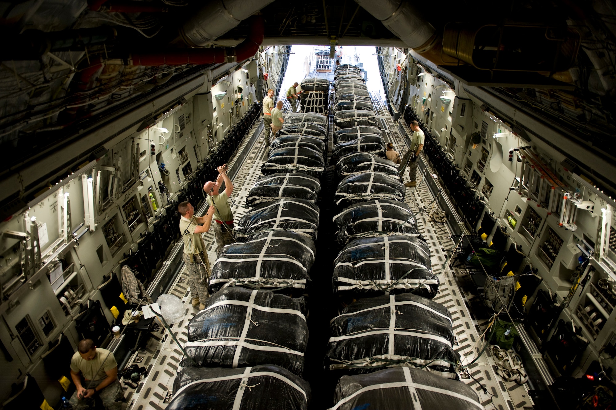 Members of the 8th Expeditionary Air Mobility Squadron and the 421st Quartermaster Company prepare bundles of jet fuel for an airdrop mission on a C-17 Globemaster III at an undisclosed location in Southwest Asia, March 28, 2012. The C-17 is one of three aerial resupply platforms utilized by U.S. Air Forces Central's Air Mobility Division. In 2011, the AMD directed the dropping of over 58,000 bundles comprising more than 80 million pounds of critical supplies to personnel in austere combat outposts. (U.S. Air Force photo by Staff Sgt. Greg C. Biondo)