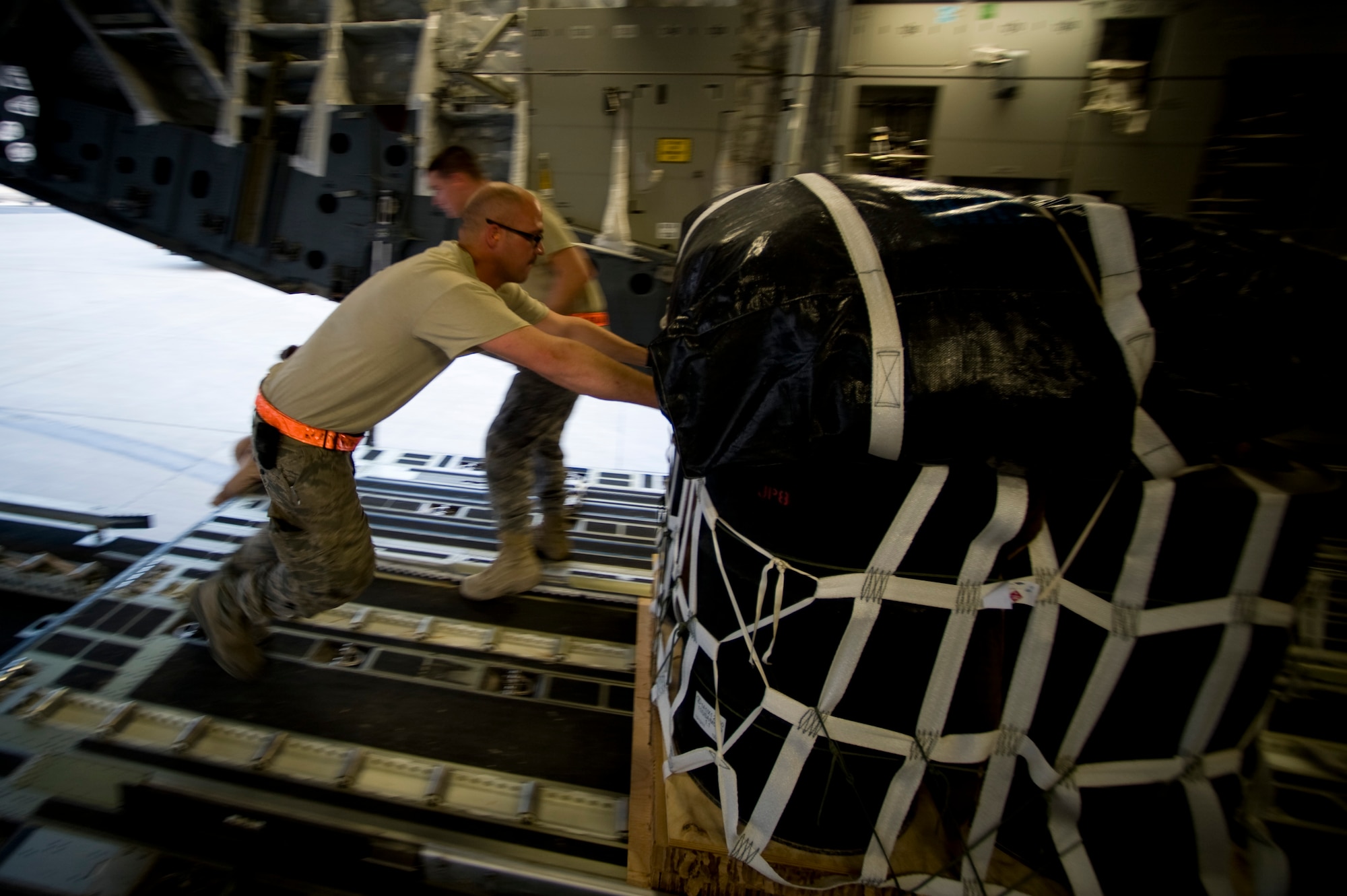 U.S. Air Force Staff Sgt. Emery Woolsey of the 8th Expeditionary Air Mobility Squadron, pushes a pallet of jet fuel onto a C-17 Globemaster III at an undisclosed location in Southwest Asia, March 28, 2012. The C-17 is one of three aerial resupply platforms utilized by U.S. Air Forces Central's Air Mobility Division. In 2011, the AMD directed the dropping of over 58,000 bundles comprising more than 80 million pounds of critical supplies to personnel in austere combat outposts. (U.S. Air Force photo by Staff Sgt. Greg C. Biondo)