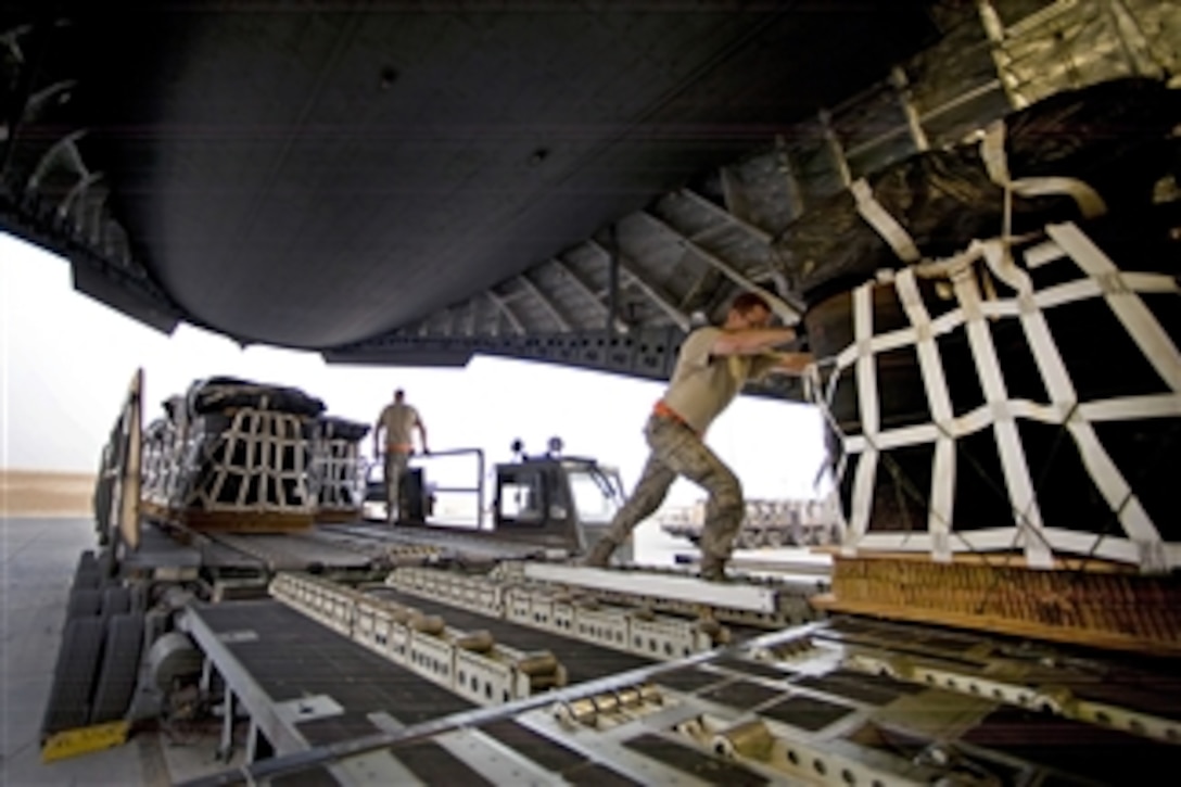 A U.S. Air Force airman pushes a pallet of jet fuel onto a C-17 Globemaster III aircraft at a location in Southwest Asia on March 28, 2012.  