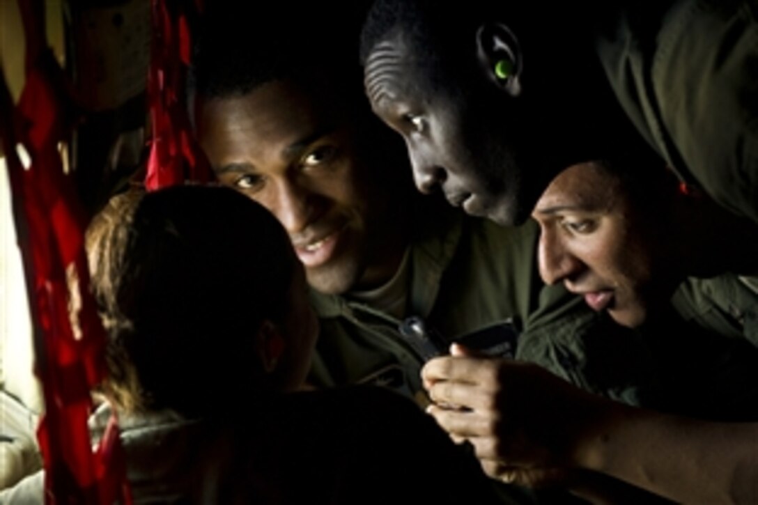 U.S. Air Force Academy Cadets Jerell Alexander, left,  Joseph Abakunda, center, and Andre Ball look out the window of a KC-135 Stratotanker as  two U.S. Air Force F-22 Raptors conduct an aerial refueling mission over the Pacific near the Hawaiian islands on March 27, 2012. The flight was part of a familiarization program to show cadets the Air Force's global reach capabilities.