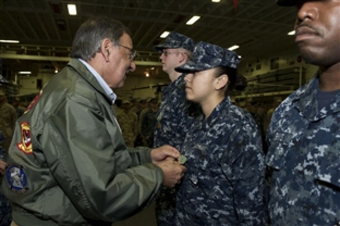 Defense Secretary Leon E. Panetta pins a medal to a sailor's uniform during his visit to the USS Peleliu in the Pacific Ocean off the coast of San Diego, March 30, 2012. The secretary visited several areas on board the ship as well as also viewing flight operations on deck. 