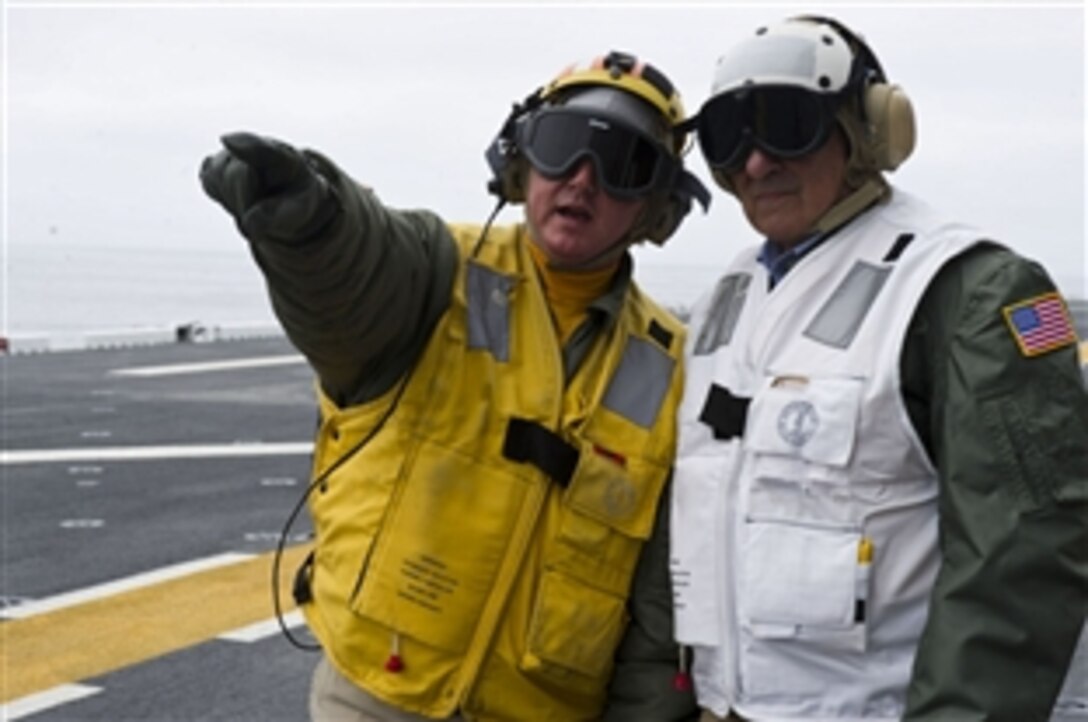 Defense Secretary Leon E. Panetta receives instructions on the landing sequence while viewing the flight deck on board the USS Peleliu in the Pacific Ocean, March 30, 2012. 

