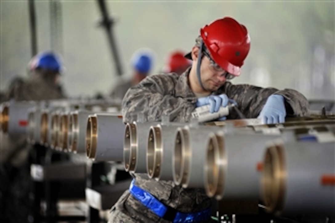 Senior Airman Daniel Stehley, of the 20th Equipment Maintenance Squadron munitions flight, spray paints build codes on inert guided bomb units after helping assemble each weapon at Shaw Air Force Base, S.C., on Feb. 27, 2012.  The weapons were assembled in preparation for an upcoming Operational Readiness Exercise.  