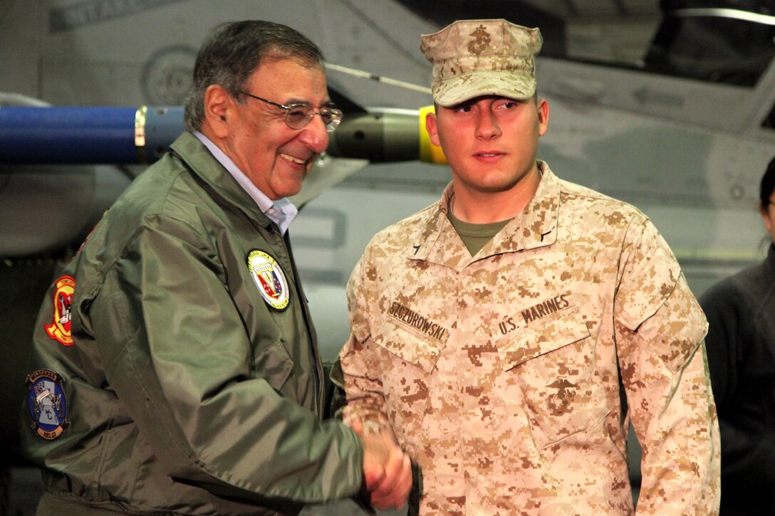 Secretary of Defense Leon Panetta presents a challenge coin to Pfc. Aryan A. Szczurowski, a rifleman with Lima Company, Battalion Landing Team 3/5, 15th Marine Expeditionary Unit, today. During his visit, Panetta toured the ship, had lunch with Marines and sailors, pinned awards on several service members, and held a brief press conference with the media. Panetta came to visit the Marines and sailors to reinforce his commitment to maintaining an expeditionary fighting force.