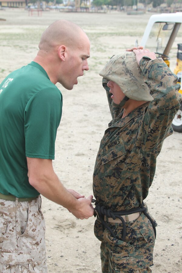 Sgt. Christopher Battaglia,Static Rope Training Specialist, Martial Arts Satellite School, Recruit Training Regiment, helps recruits by motivating them and making sure their gear is secured properly March 30 aboard Marine Corps Recruit Depot San Diego. After being checked for safety, Company C rappelled off the 60 foot tower.