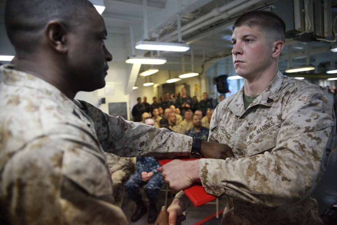 Cpl. Chad J. Chedrick receives a certificate from Gunnery Sgt. Michael M. Freeman aboard USS Makin Island here March 30 during a Corporals Course graduation ceremony. Chedrick serves with Battalion Landing Team 3/1, the ground combat element for the 11th Marine Expeditionary Unit. The unit is deployed as part of the Makin Island Amphibious Ready Group, a U.S. Central Command theater reserve force. The group is providing support for maritime security operations and theater security cooperation efforts in the U.S. Navy's 5th Fleet area of responsibility.