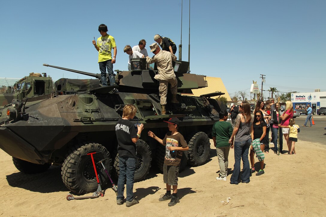 Kids play on a light armored vehicle which is part of the military display during the annual Baileys Car Show across the street from David Baileys Auto Repair and Towing March 31, 2012. The show hosted more than 100 vehicles including cars, trucks, motorcycles, military vehicles and a fire truck.