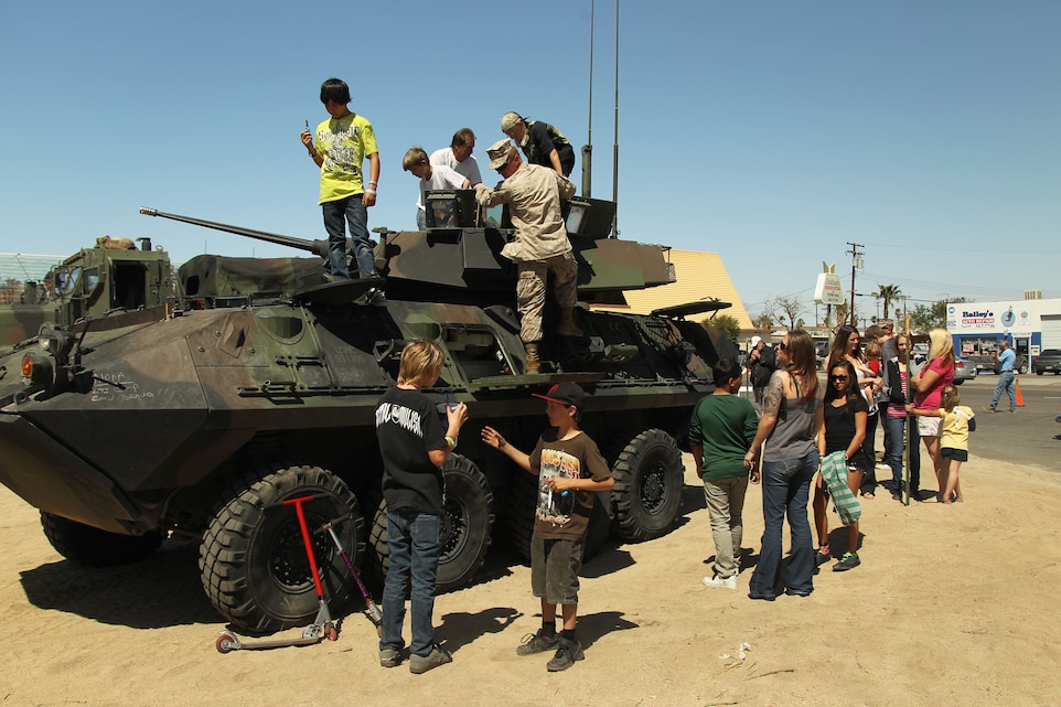 Kids play on a light armored vehicle which is part of the military display during the annual Baileys Car Show across the street from David Baileys Auto Repair and Towing March 31, 2012. The show hosted more than 100 vehicles including cars, trucks, motorcycles, military vehicles and a fire truck.