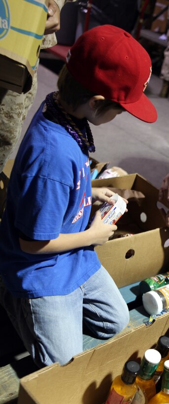 A volunteer inspects a box of medicine while sorting through a box of food at the Food Bank of Central and Eastern North Carolina in Greenville, N.C., March 31, 2012. The children from local volunteer centers and Marines from 2nd Maintenance Battalion, 2nd Marine Logistics Group dug through multiple pallets of food to organize it for monthly distribution.