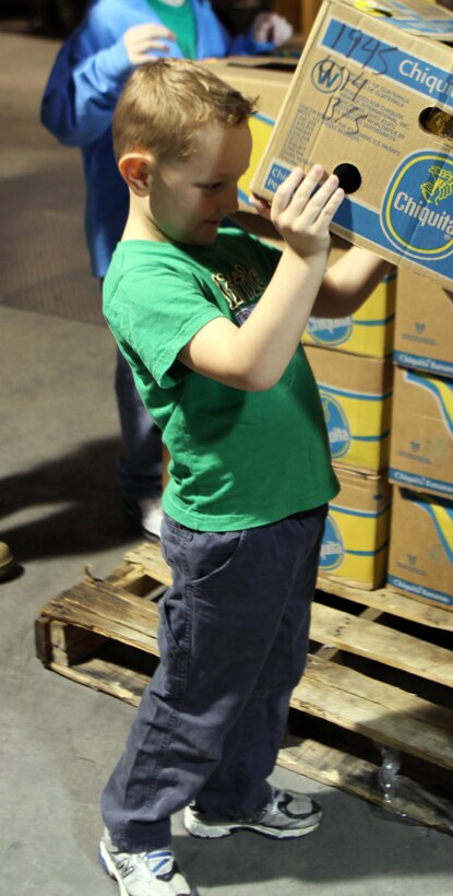 A volunteer lifts a box of food off of one of the many of pallets that were sorted at the Food Bank of Central and Eastern North Carolina in Greenville, N.C., March 31, 2012. The children from local volunteer centers and Marines from 2nd Maintenance Battalion, 2nd Marine Logistics Group worked for two hours sorting through boxes of food to prepare it for monthly distribution.