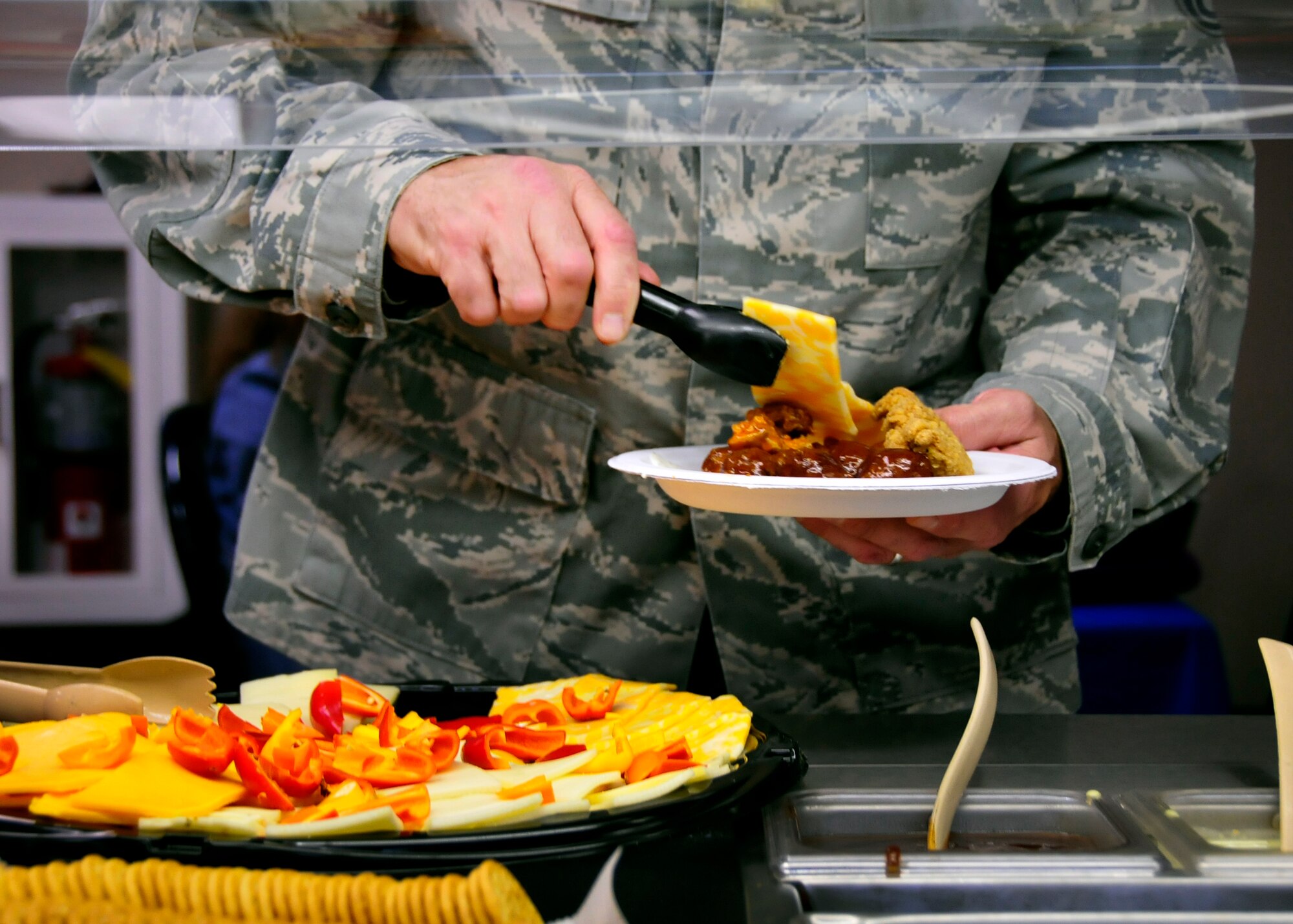 An Airman fills his plate with the free food provided at the grand opening of the newly remodeled Outpost at Duke Field, Fla., recently.  The grand opening featured free food, games and a live band to showcase the new facility.  The Outpost houses Gulf Coast Eats. The hours of operation are Monday-Friday 11 a.m. to 1 p.m. for lunch, Fridays and UTA Saturdays 3-8 p.m. The Outpost serves pizza, hotdogs, popcorn, pretzels and nachos during its evening hours. (U.S. Air Force photo/Tech. Sgt. Jasmin Taylor)