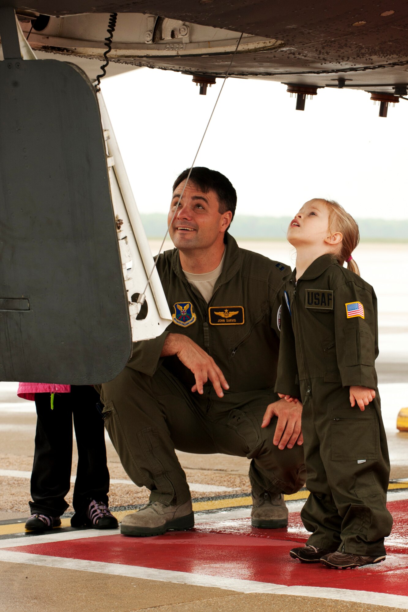 U.S. Air Force Capt. John Sarvis and Julie Gilman wait for their turn to climb up into the cockpit of a B-52 Stratofortress at Barksdale Air Force Base, La., March 30 2012. Sarvis and Julie's dad, 1st Lt. Craig Gilman, are graduates of the B-52 Formal Training Unit after spending 9 months at Barksdale learning to fly the B-52. (U.S. Air Force photo by Master Sgt. Greg Steele/Released)