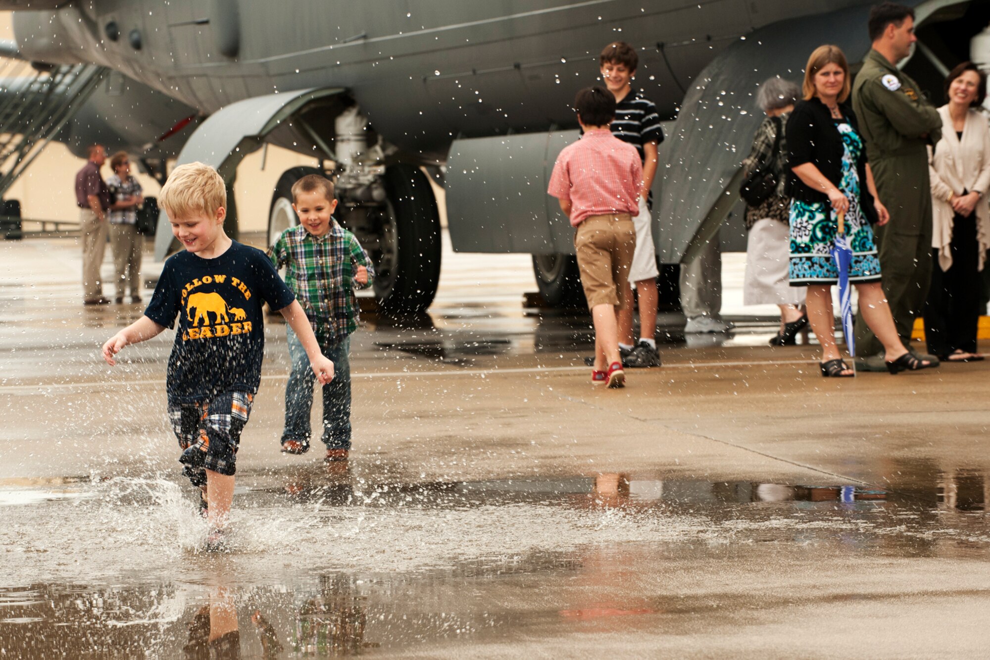 Andrew Sarvis and Elijah Frazier enjoy the results of a morning rain shower at Barksdale Air Force Base, La., March 30, 2012. Andrew is the son of U.S. Air Force Capt. John Sarvis, who graduated from the B-52 Formal Training Unit Class 11-03 and recipient of the Lindell Mabus Leadership Award. (U.S. Air Force photo by Master Sgt. Greg Steele/ Released)