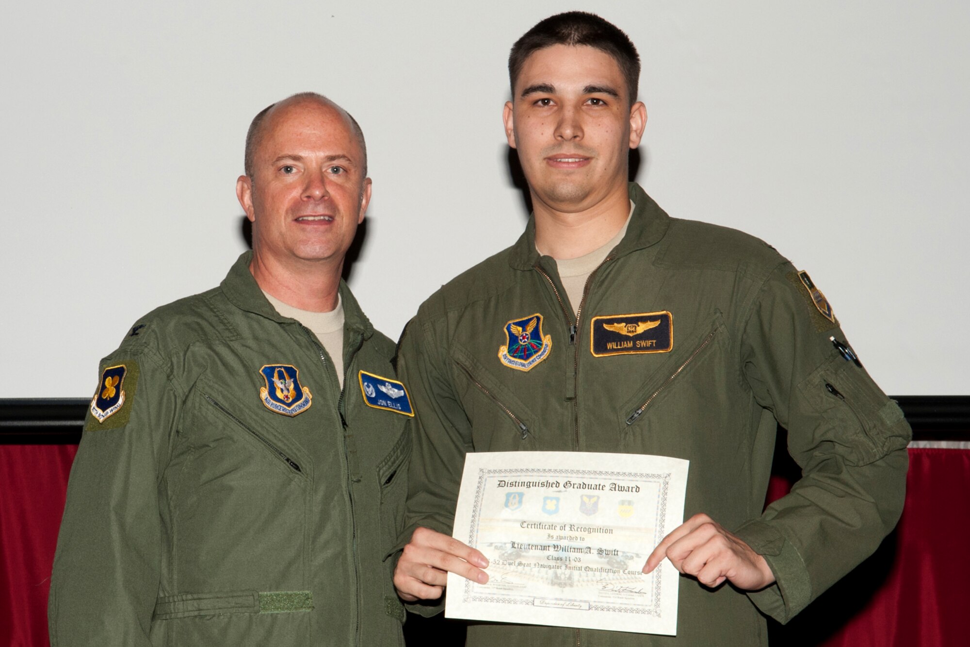 U.S. Air Force Col. Jon Ellis, 307th Bomb Wing commander, presents a Distinguished Graduate certificate to 1st Lt. William Swift during the Formal Training Unit Class 11-03 graduation ceremony on Barksdale Air Force Base, La., March 30, 2012. Swift, a Dual Seat Navigator graduate, demonstrated at least a 90 percent average in all areas of training and performed consistently and clearly above his peers. (U.S. Air Force photo by Master Sgt. Greg Steele/Released)