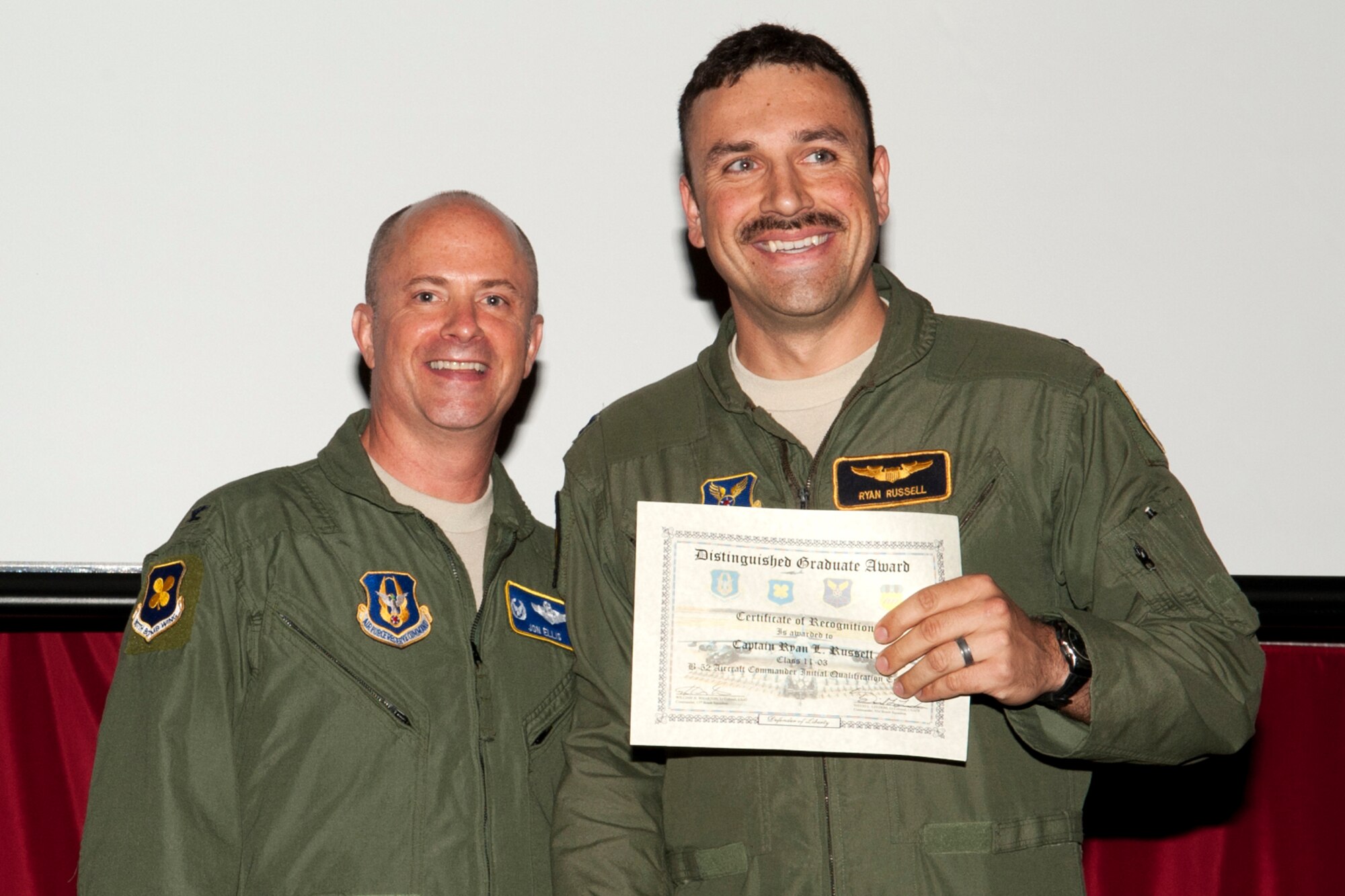 U.S. Air Force Col. Jon Ellis, 307th Bomb Wing commander, presents a Distinguished Graduate certificate to Capt. Ryan Russell during the Formal Training Unit Class 11-03 graduation ceremony on Barksdale Air Force Base, La., March 30, 2012. Russell, a Pilot graduate, demonstrated at least a 90 percent average in all areas of training and performed consistently and clearly above his peers. (U.S. Air Force photo by Master Sgt. Greg Steele/Released)