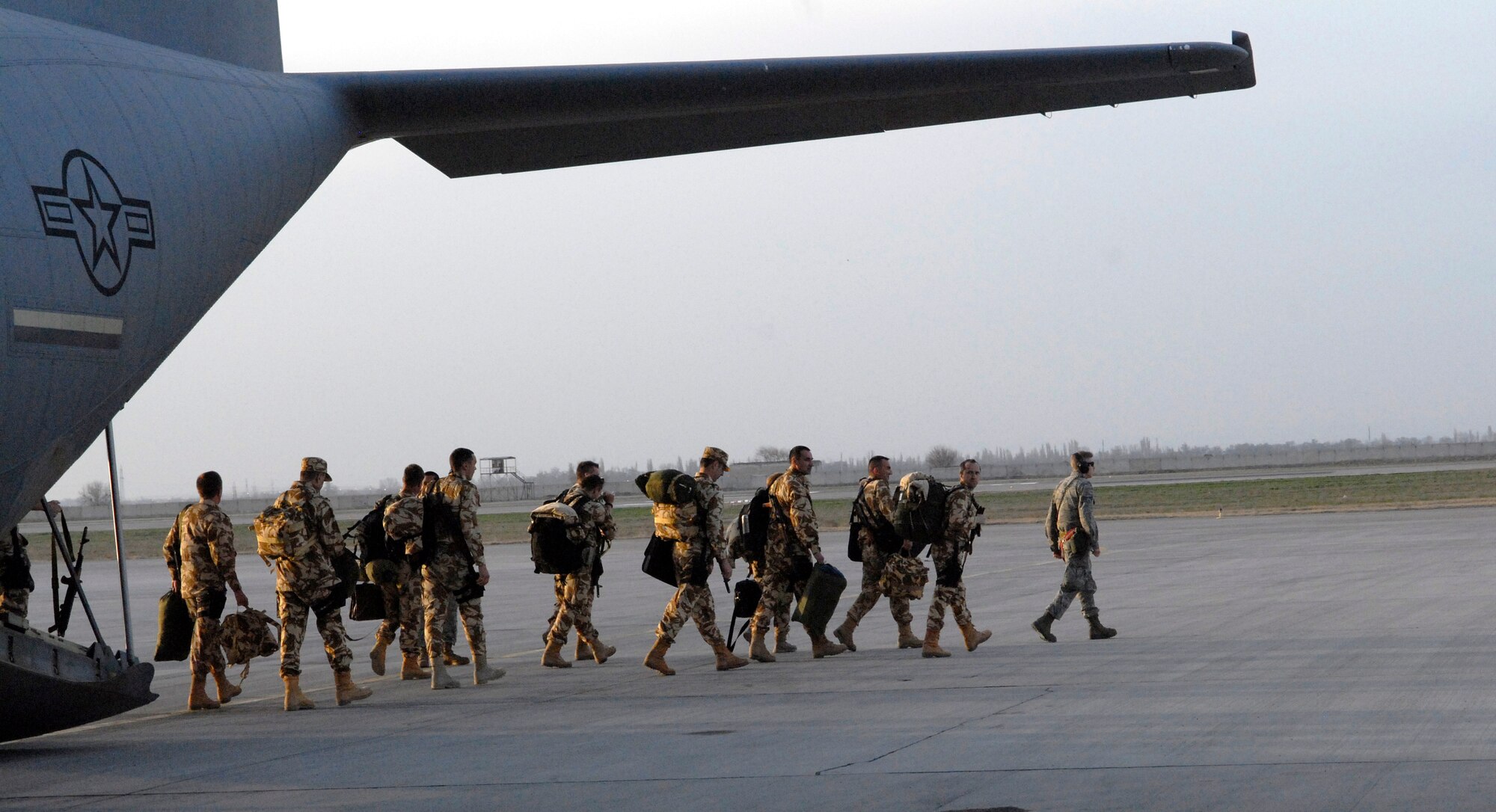 Coalition forces file out of a C-130J Super Hercules at the Transit Center at Manas, Kyrgyzstan, March 31, 2012. Service members at the Transit Center at Manas work side-by-side with Kyrgyz partners every day to support international efforts in Afghanistan by moving fuel, cargo and people.  Last week, the team moved a record 19,827 coalition troops, the most since the installation opened 10 years ago. (U.S. Air Force photo/Senior Airman Lynsie Nichols)