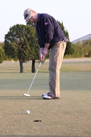 Col. James C. Stewart, Marine Corps Air Station Iwakuni commanding officer, keeps his eye fixed on the ball while landing a successful putt on the final day of play of the Torii Pines Golf Course here April 1. Stewart recalled fond memories as each hole held its own story since the time the he first stepped foot on station.