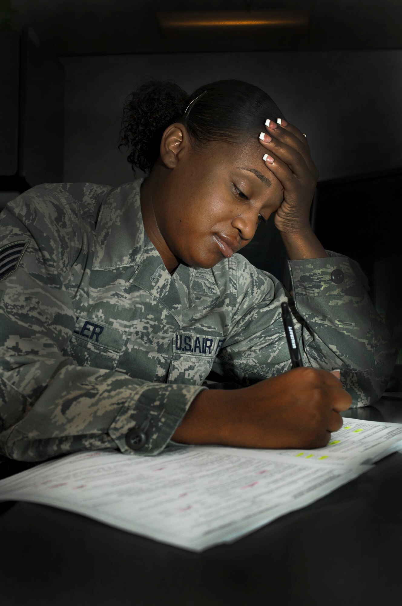 Staff Sgt. Stephanie Miller, 99th Logistics Readiness Squadron, strains to prepare travel documents for a permanent change of station. The peak PCS period is between Memorial Day and Independence Day. The volume of PCSs during that time could cause lengthy delays for those who are unprepared or procrastinate. (Photo Illustration by Senior Airman Jack Sanders)

