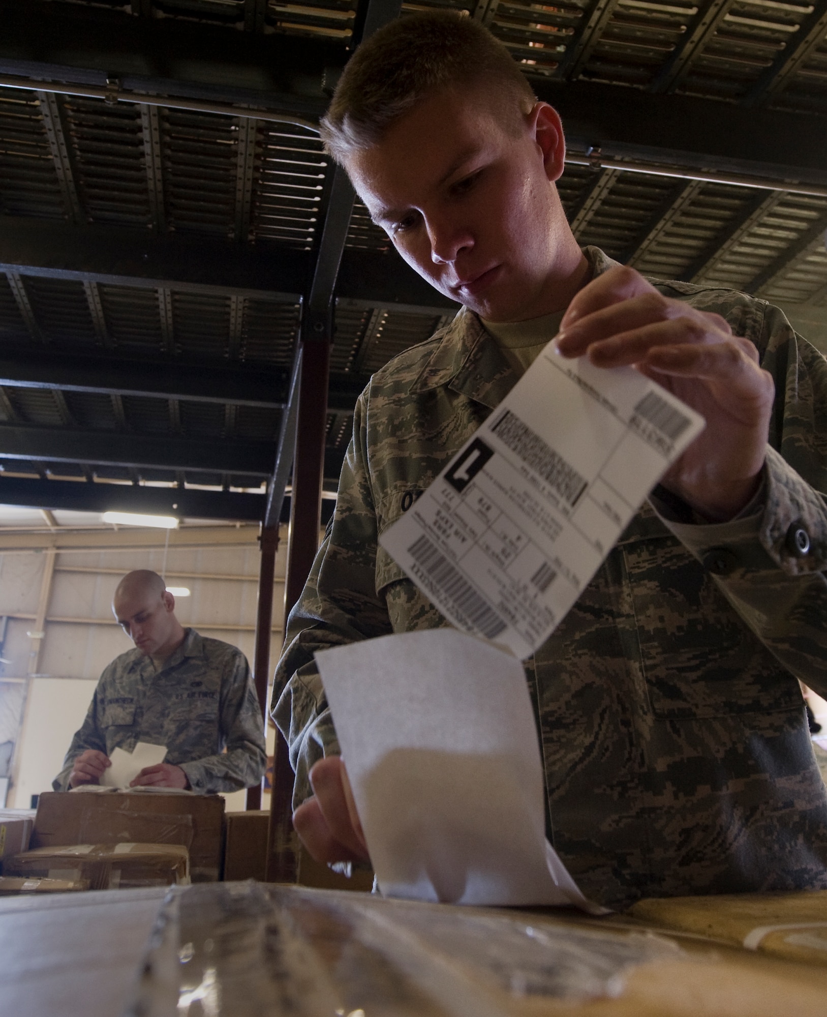 Senior Airman Steven Romancheck (left) and Airman 1st Class Alexander Oas (right), 99th Logistics Readiness Squadron traffic management journeymen, label cargo May 1, 2012, at Nellis Air Force Base, Nev. Air Force Logistic Readiness Squadrons are responsible for moving many forms of cargo across the world. (U.S. Air Force photo by Staff Sgt. Christopher Hubenthal)

