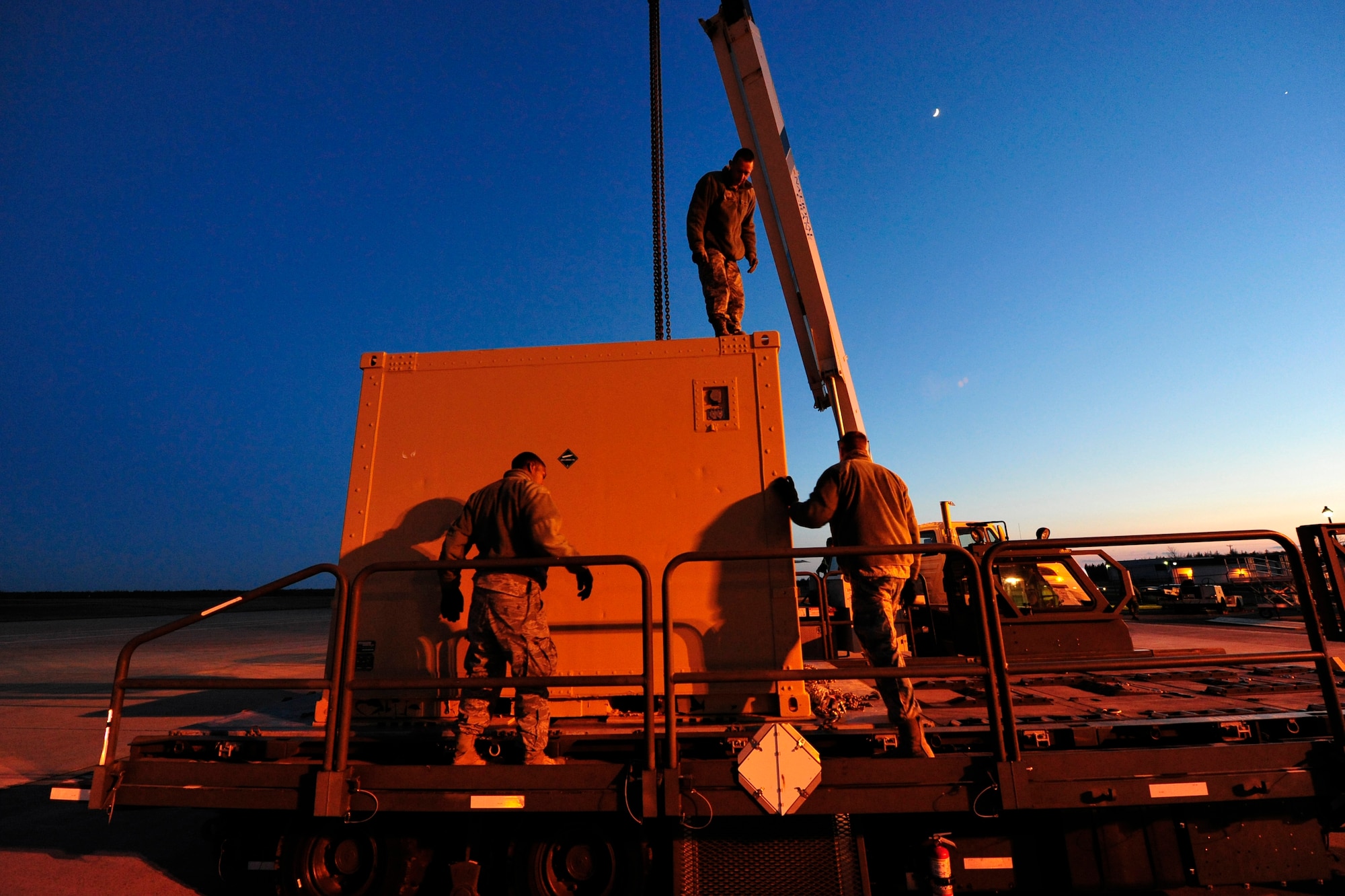 SYDNEY, Nova Scotia -- From left: Senior Airman Casey Jones, Senior Airman James Weimer and Staff Sgt. Dustin Pavleski, air transportation journeymen assigned to the 621st Contingency Response Wing at Joint Base McGuire-Dix-Lakehurst, N.J., prepare to hoist a container of dive equipment from a next generation small loader here, April 26.  The three were deployed to provide air mobility cargo handling expertise to the U.S. Navy’s Explosive Ordinance Disposal Mobile Unit 12, based at Little Creek, Va., for their deployment to Exercise Ardent Sentry 2012. (U.S. Air Force photo by Tech. Sgt. Parker Gyokeres) (Released)