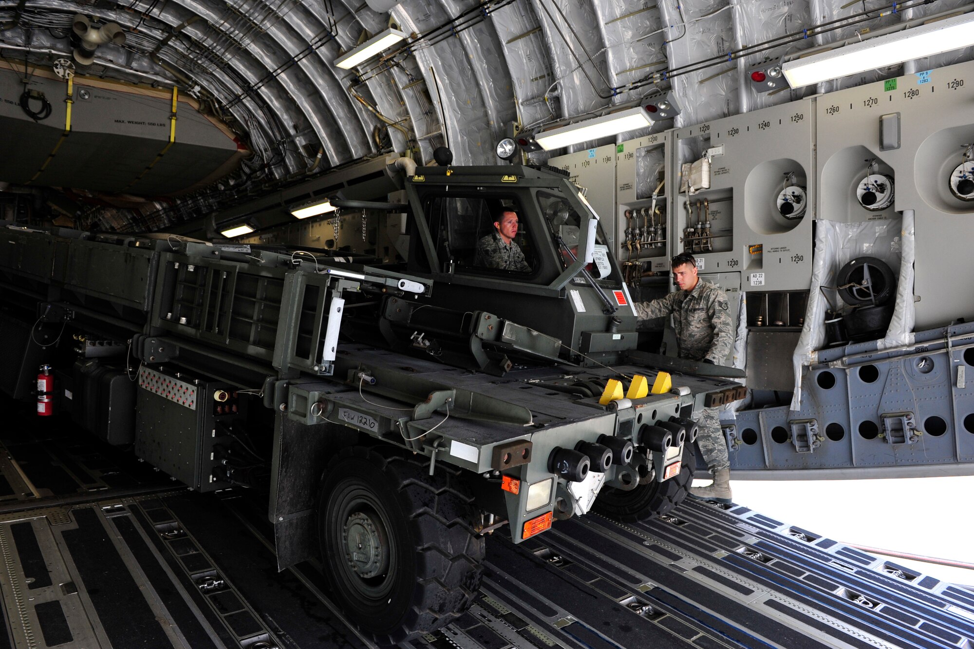 NAVAL STATION NORFOLK, Va. -- Staff Sgt. Dustin Pavleski guides Senior Airman James Weimer as they back a next generation small loader onto a C-17 Globemaster III at Naval Station Norfolk, Va., April 26.  Pavleski and Weimer are air transportation journeymen assigned to the 621st Contingency Response Wing at Joint Base McGuire-Dix-Lakehurst, N.J. The JB MDL-based aircraft was transporting a team of Sailors from the U.S. Navy’s Explosive Ordinance Disposal Mobile Unit 12 to participate in Exercise Ardent Sentry 2012, a major NORAD and U.S Northern Command exercise focused on defense support to civil authorities. (U.S. Air Force photo by Tech. Sgt. Parker Gyokeres) (Released)
