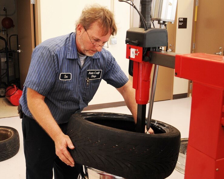 Tom Hunnicutt, 2nd Force Support Squadron Auto Craft Shop mechanic, removes a tire from its rim on Barksdale Air Force Base, La. May 1. The tire machine is used to change large and low profile tires. The Auto Craft Shop will have its grand opening May 22. (U.S. Air Force photo/Senior Airman Sean Martin)(RELEASED)