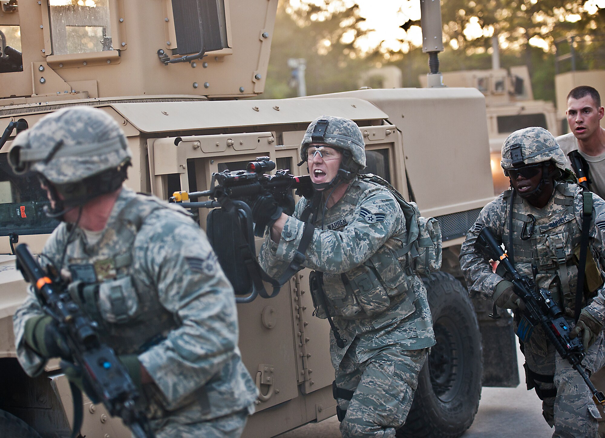 Senior Airman Robert Warren, of the 22nd Security Forces Squadron, yells for his squad to move out of the village during the final mission of the three-day Brave Defender field training exercise April 28 at Eglin Air Force Base, Fla.  The exercise is the culmination of Air Force Materiel Command’s six-week security forces deployment training, administered by the 96th Ground Combat Training Squadron. GCTS instructors teach 10 training classes a year, which consists of improvised explosive device detection and reaction, operating in an urban environment, mission planning, land navigation, casualty care and more. More than 100 active-duty and National Guard Airmen attended this training. (U.S. Air Force photo/Samuel King Jr.)
