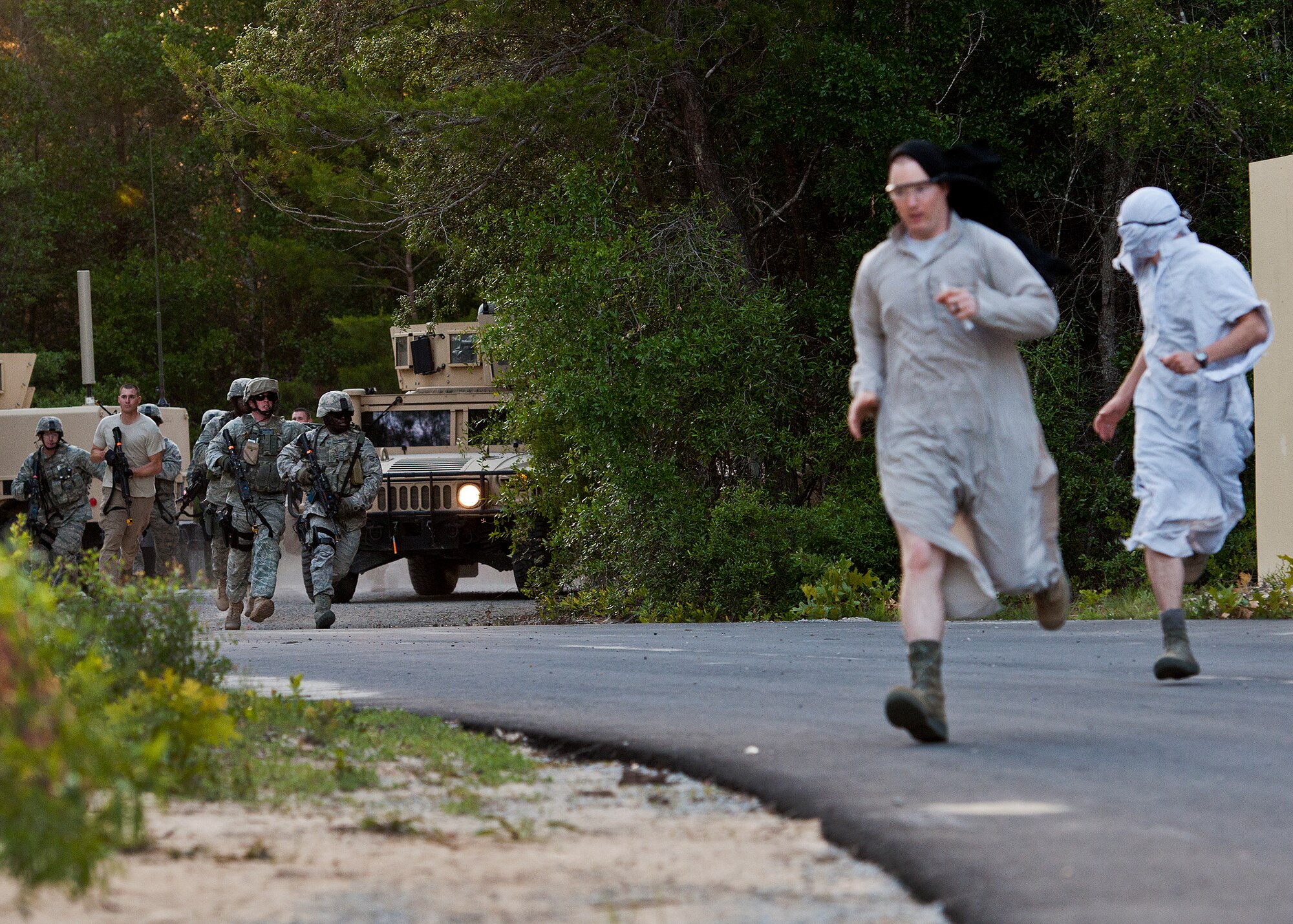 Villagers run from security forces Airmen as they enter the village to recover a high value target during the final mission of the three-day Brave Defender field training exercise April 28 at Eglin Air Force Base, Fla.  The exercise is the culmination of Air Force Materiel Command’s six-week security forces deployment training, administered by the 96th Ground Combat Training Squadron. GCTS instructors teach 10 training classes a year, which consists of improvised explosive device detection and reaction, operating in an urban environment, mission planning, land navigation, casualty care and more. More than 100 active-duty and National Guard Airmen attended this training. (U.S. Air Force photo/Samuel King Jr.)