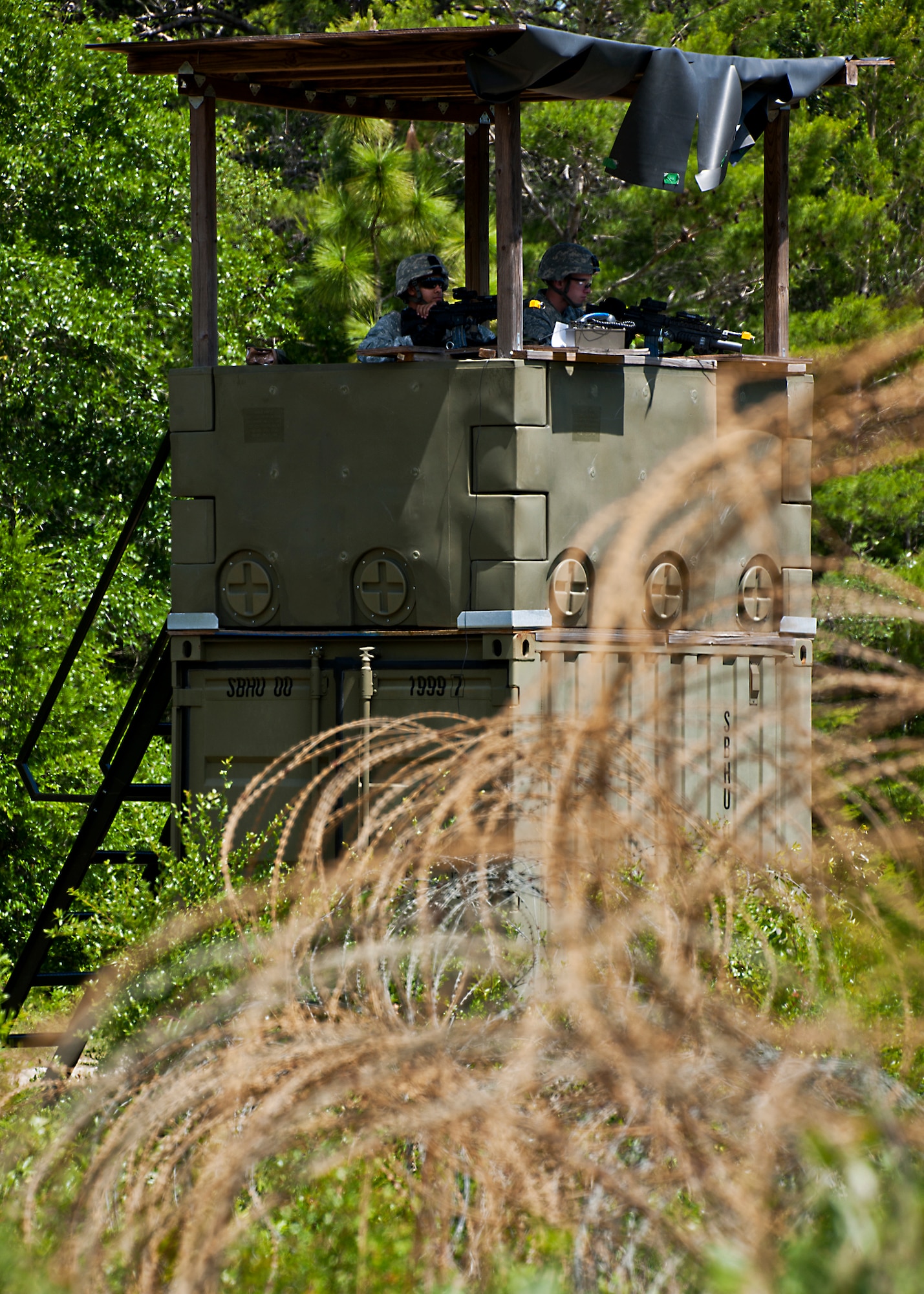 Security Forces Airmen scan the treeline from their watchtower during the three-day Brave Defender field training exercise April 28 at Eglin Air Force Base, Fla.  The exercise is the culmination of Air Force Materiel Command’s six-week security forces deployment training, administered by the 96th Ground Combat Training Squadron. GCTS instructors teach 10 training classes a year, which consists of improvised explosive device detection and reaction, operating in an urban environment, mission planning, land navigation, casualty care and more. More than 100 active-duty and National Guard Airmen attended this training. (U.S. Air Force photo/Samuel King Jr.)
