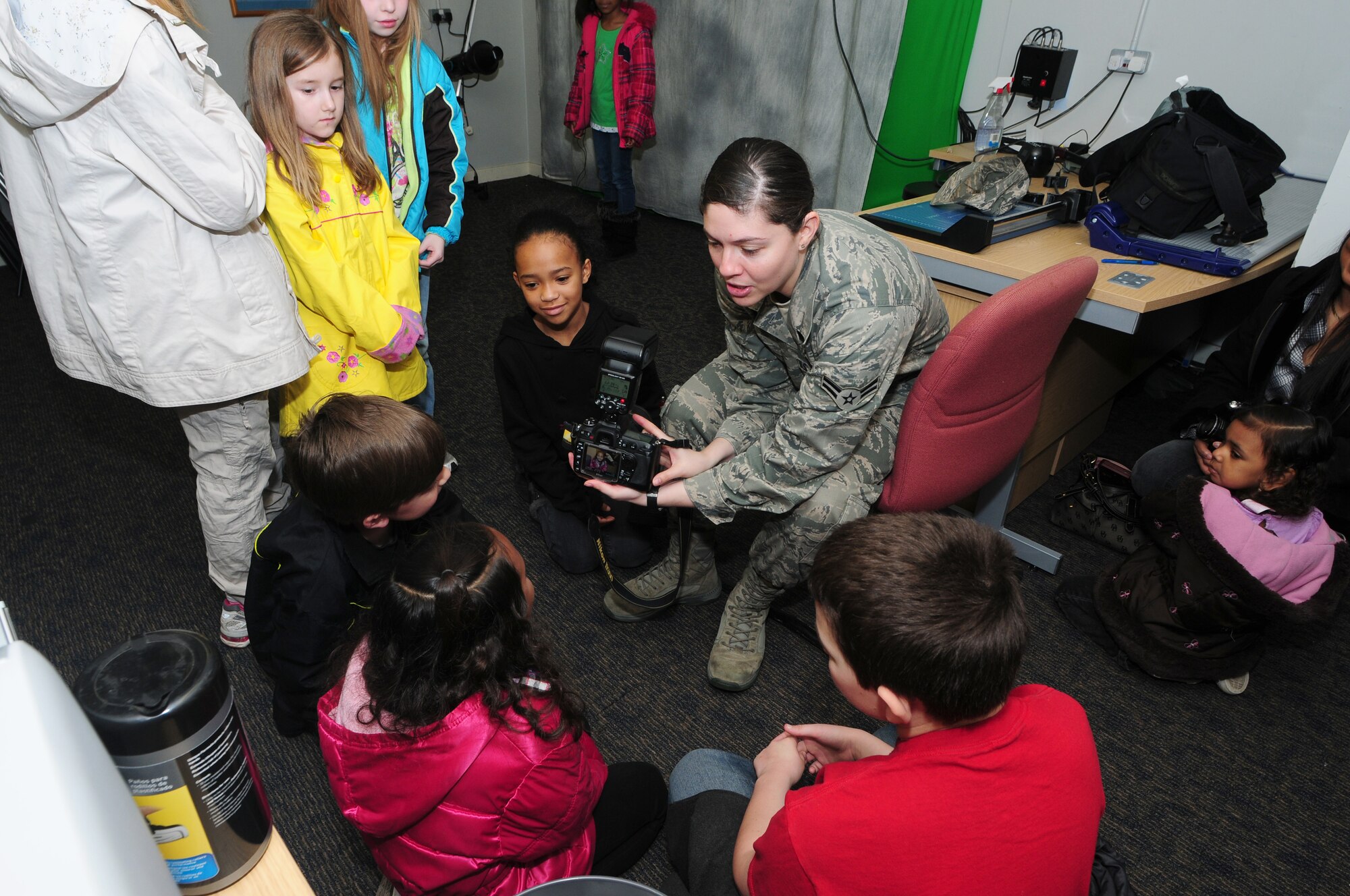 ROYAL AIR FORCE LAKENHEATH, England -- Airman 1st Class Erin Mills, 48th Fighter Wing Public Affairs broadcaster, shows students how to operate a camera during Job Shadow Day at RAF Lakenheath, England, April 27, 2012.  Job Shadow Day provided children the opportunity to see and learn about different Air Force jobs and allowed hands-on experience in an interactive environment. (U.S. Air Force photo by Senior Airman Tiffany M. Deuel)
