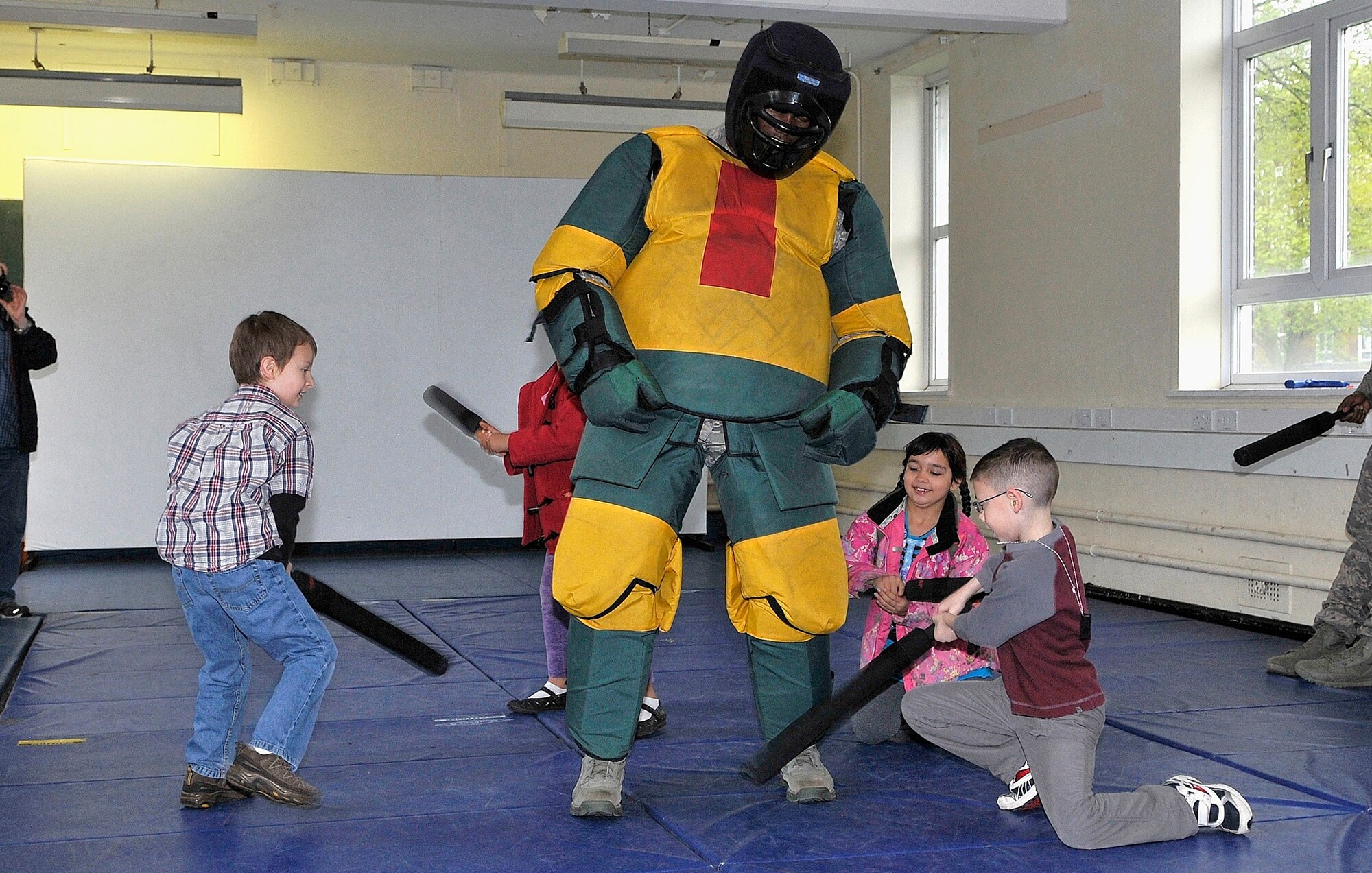 ROYAL AIR FORCE LAKENHEATH, England -- Feltwell and Lakenheath Elementary School students learn how to use batons on Tech. Sgt. Lamont Goodwin, 48th Security Forces Squadron unit trainer, at a demonstration on Job Shadow Day at RAF Feltwell, England, April 27, 2012.  Job Shadow Day provided children the opportunity to see and learn about different Air Force jobs and allowed hands-on experience in an interactive environment. (U.S. Air Force photo by Staff Sgt. Connor Estes)
