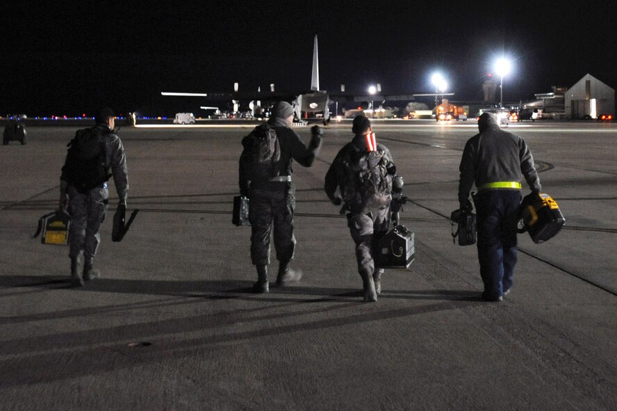 Crew chiefs from the 27th Special Operations Aircraft Maintenance Squadron carry their tools to the AC-130H Spectre gunship as they prepare for a nightly inspection of the aircraft.  Many squadrons, such as the 27 SOAMS are operational 24/7 to keep aircraft in the air no matter what time it is.  (U.S. Air Force photo by Senior Airman Jette Carr)