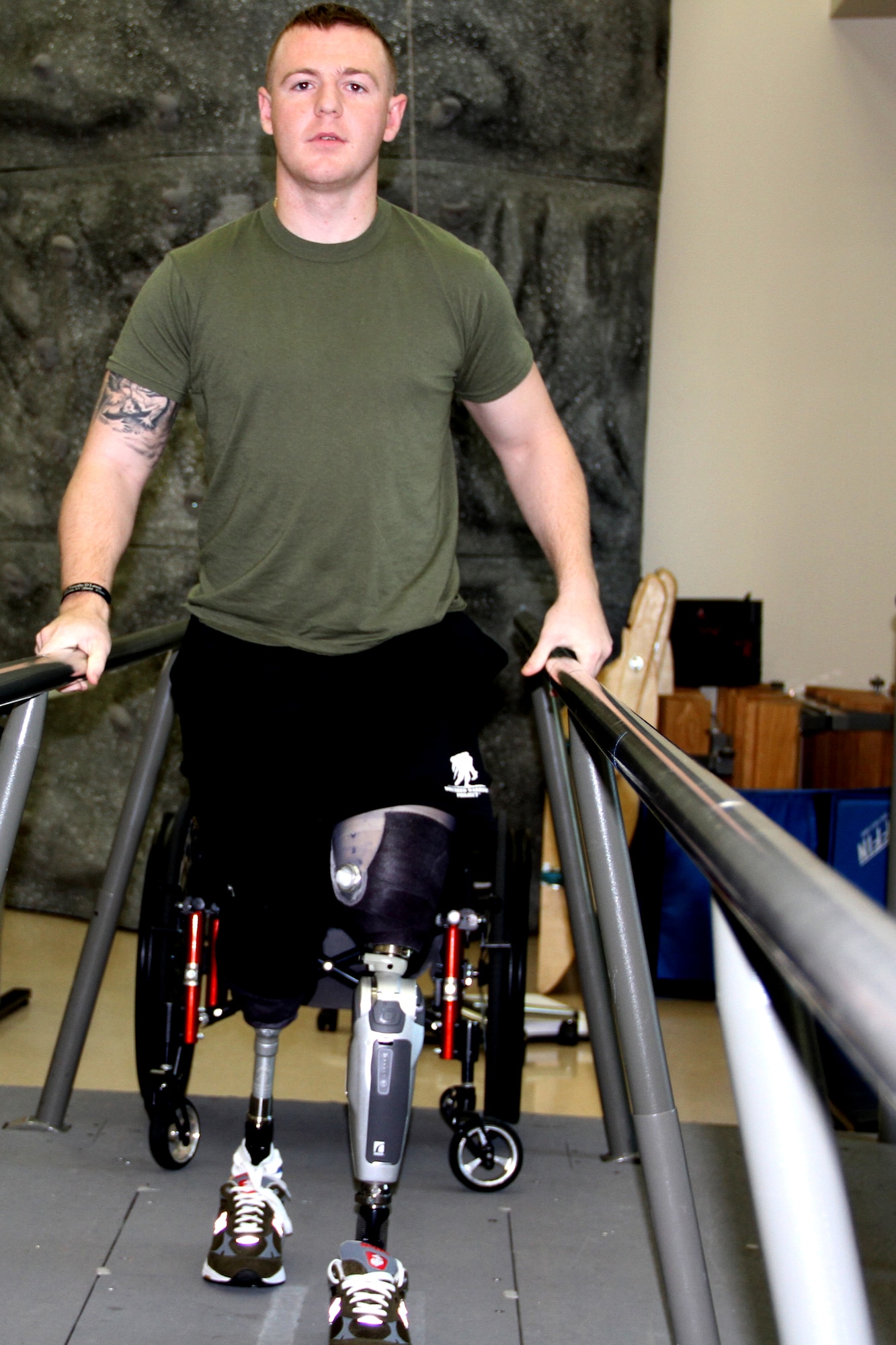 Marine Corps Cpl. Garrett Carnes walks the length of a slightly elevated ramp one day after wearing his new prosthetic legs for no more than 10 minutes at Walter Reed National Military Medical Center, Bethesda, Md., April 24, 2012. (DOD photo/Terri Moon Cronk) 

