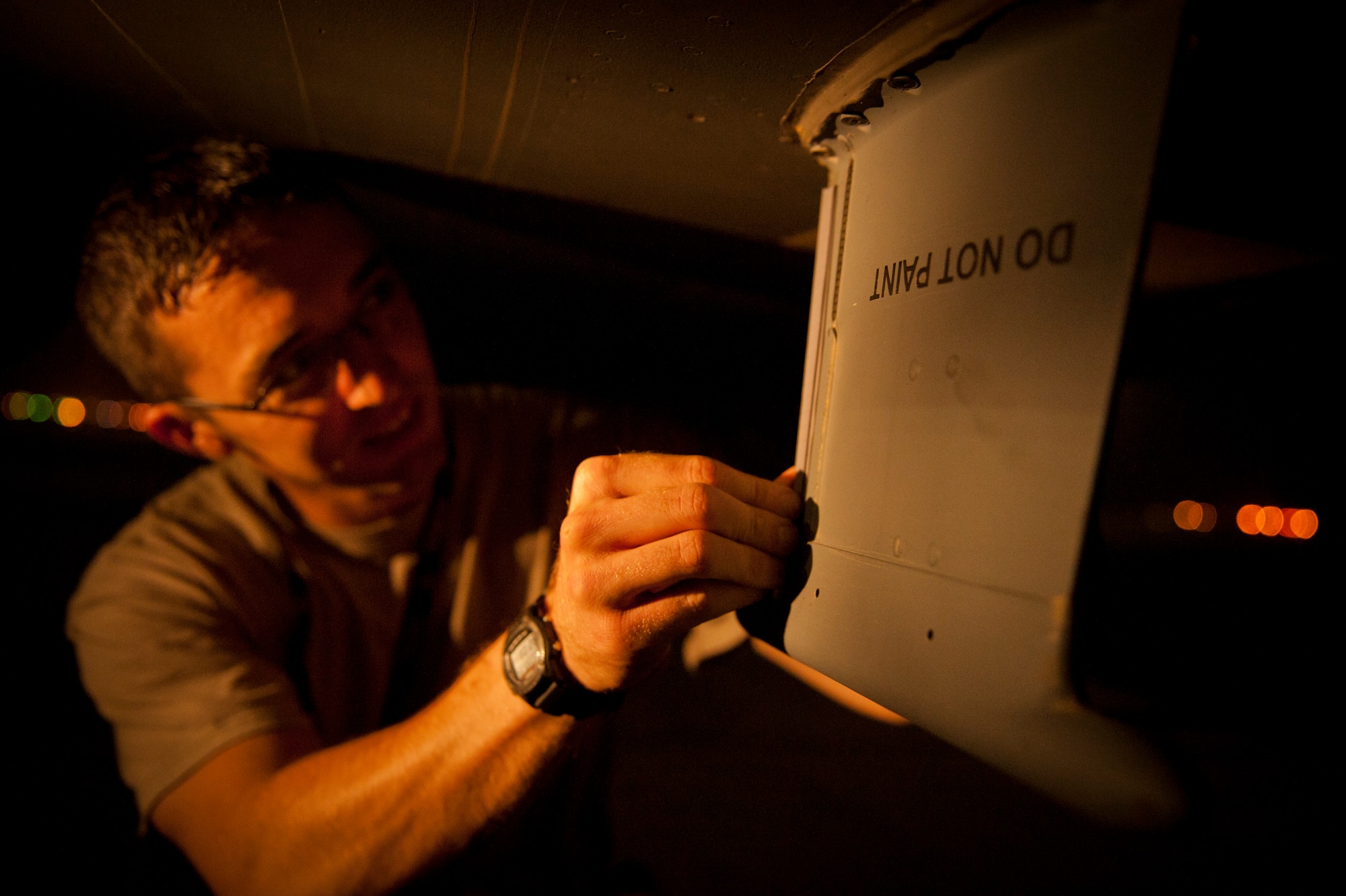 SOUTHWEST ASIA – Tech. Sgt. Ryan Francois, 8th Expeditionary Air Mobility Squadron communications and navigation specialist, applies tape to the front of an antenna underneath a C-17 Globemaster III here April 30. The tape protects the antennas under the C-17 from rocks and debris that kick up while landing on an unpaved landing strip. Each antenna costs anywhere from $20,000 to $50,000. (U.S. Air Force photo/Staff Sgt. Nathanael Callon)