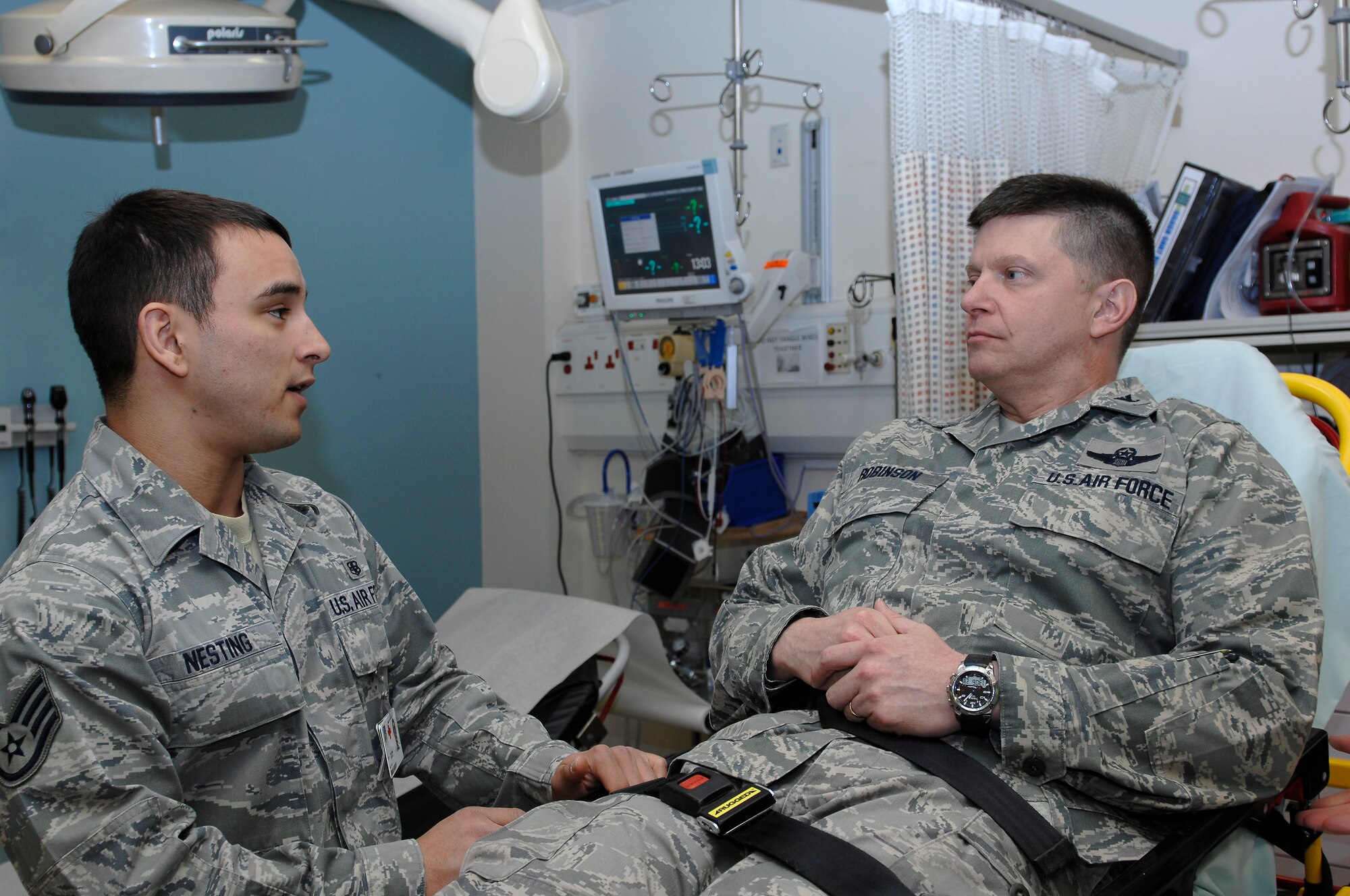 ROYAL AIR FORCE LAKENHEATH, England -- Staff Sgt. Wes Nesting, 48th Medical Operations Squadron medical technician, talks with Col. Kyle Robinson, 48th Fighter Wing commander, about what led him into the emergency room April 25, 2012. The 48th Medical Group enacted a creative initiative to give the wing’s new commander insight into their operations. As part of the simulation Robinson felt ‘abdominal pains’ following a working lunch with Chief Master Sgt. SaRita Lathan, 48th Fighter Wing command chief, and when the pains worsened she dialed 911. (U.S. Air Force photo by Tech. Sgt. Lee A. Osberry Jr.)