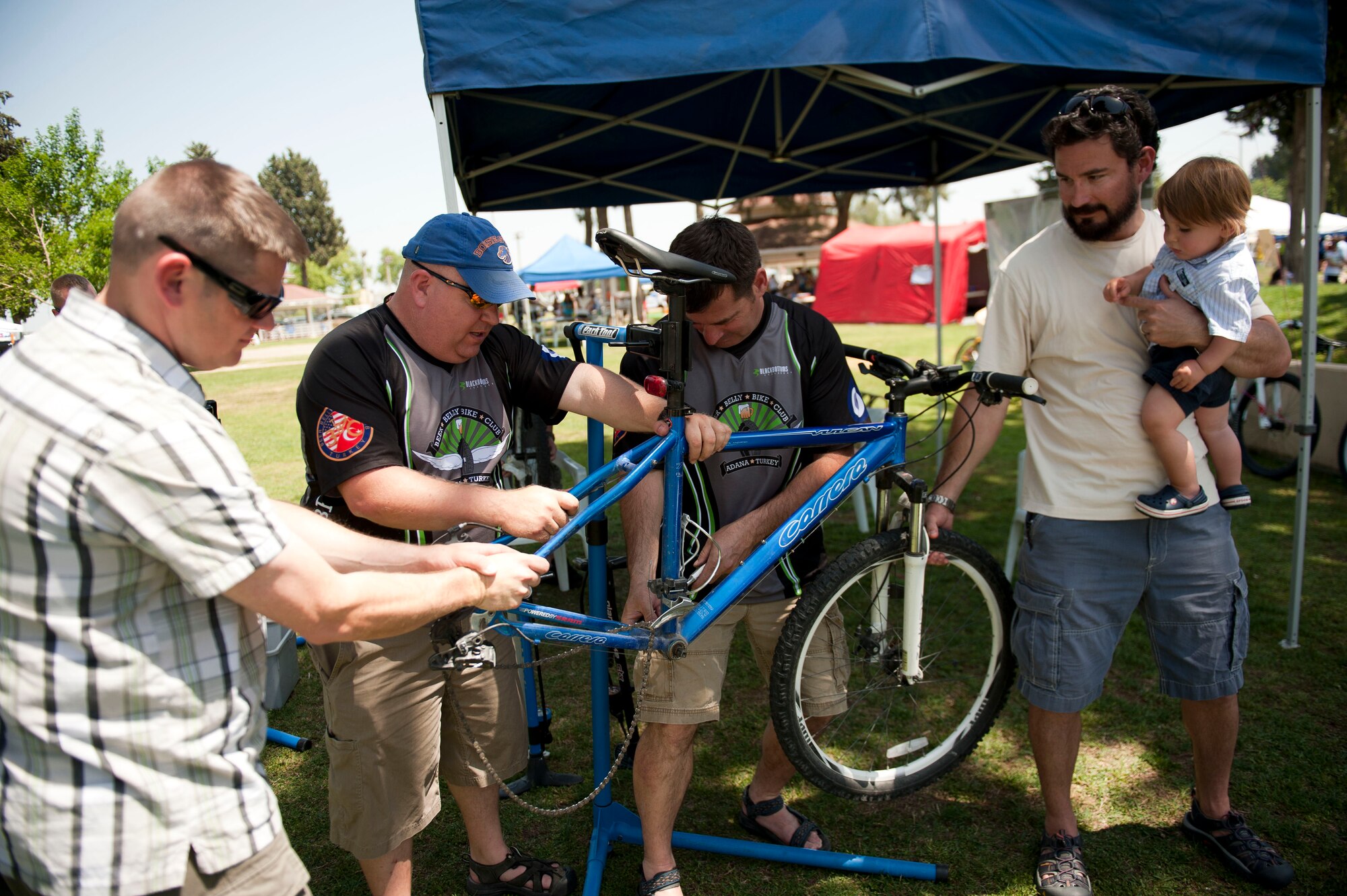 Members of the Beer Belly Bike Club perform a free tune-up on a bicycle during the Spring Fling April 28, 2012, at Incirlik Air Base, Turkey. The event offered members of Team Incirlik a chance to enjoy warmer weather while taking part in various fair-style activities. (U.S. Air Force photo by Senior Airman Clayton Lenhardt/Released)