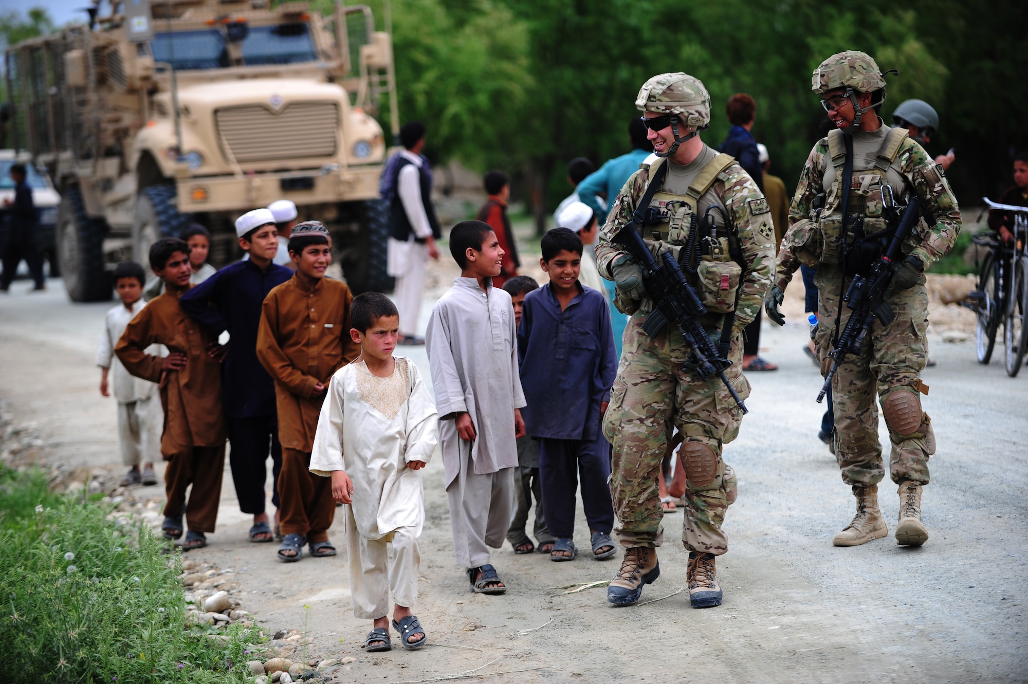 U.S. Air Force civil engineers Capt. Hans Winkler of the 633rd Civil Engineer Squadron, Joint Base Langley-Eustis, Va., and 1st Lt. Jasamine Pettie of the 60th Civil Engineer Squadron, Travis Air Force Base, Calif., talk to children in the Laghman province, Afghanistan April 19, 2012. The engineers are deployed to the Laghman Provincial Reconstruction Team, tasked to help increase local government infrastructure in the Laghman Province. (U.S. Air Force photo/Tech. Sgt. DeNoris A. Mickle)