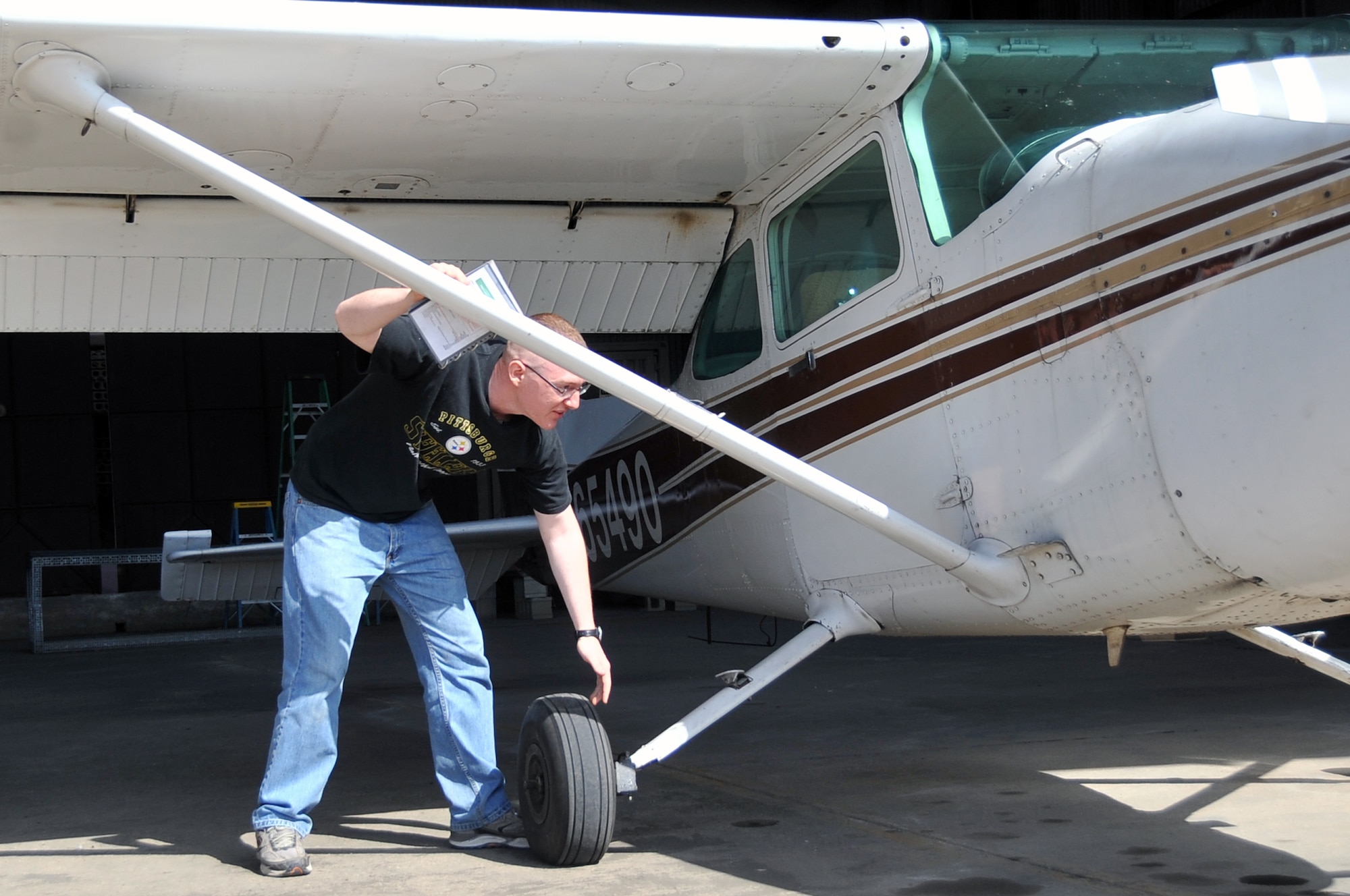 Senior Airman Joseph Cider, 51st Maintenance Squadron aircraft structural maintainer, performs a structural aircraft check prior to taking a Cessna 172 aircraft out of the hangar here April 30, 2012. Cider is a member of the 51st Force Support Squadron Aero Club. (U.S. Air Force photo/Staff Sgt. Craig Cisek)